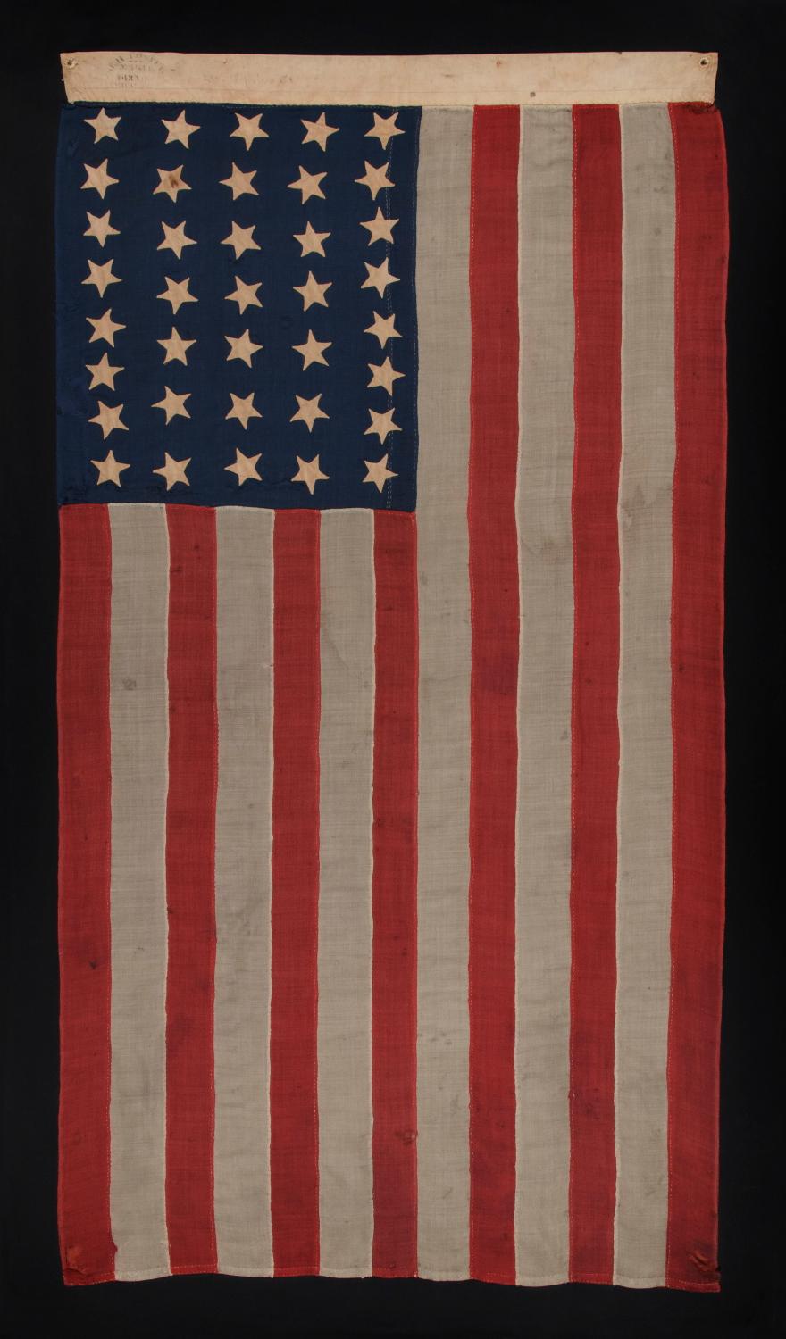 37 STAR ANTIQUE AMERICAN FLAG, ENTIRELY HAND SEWN AND IN AN ATTRACTIVE, SMALL SCALE FOR THE PERIOD, MADE BY JOSEPH H. FOSTER IN PHILADELPHIA BETWEEN 1867-1876, THE PERIOD WHEN NEBRASKA WAS THE MOST RECENT STATE TO JOIN THE UNION:

Entirely hand sewn