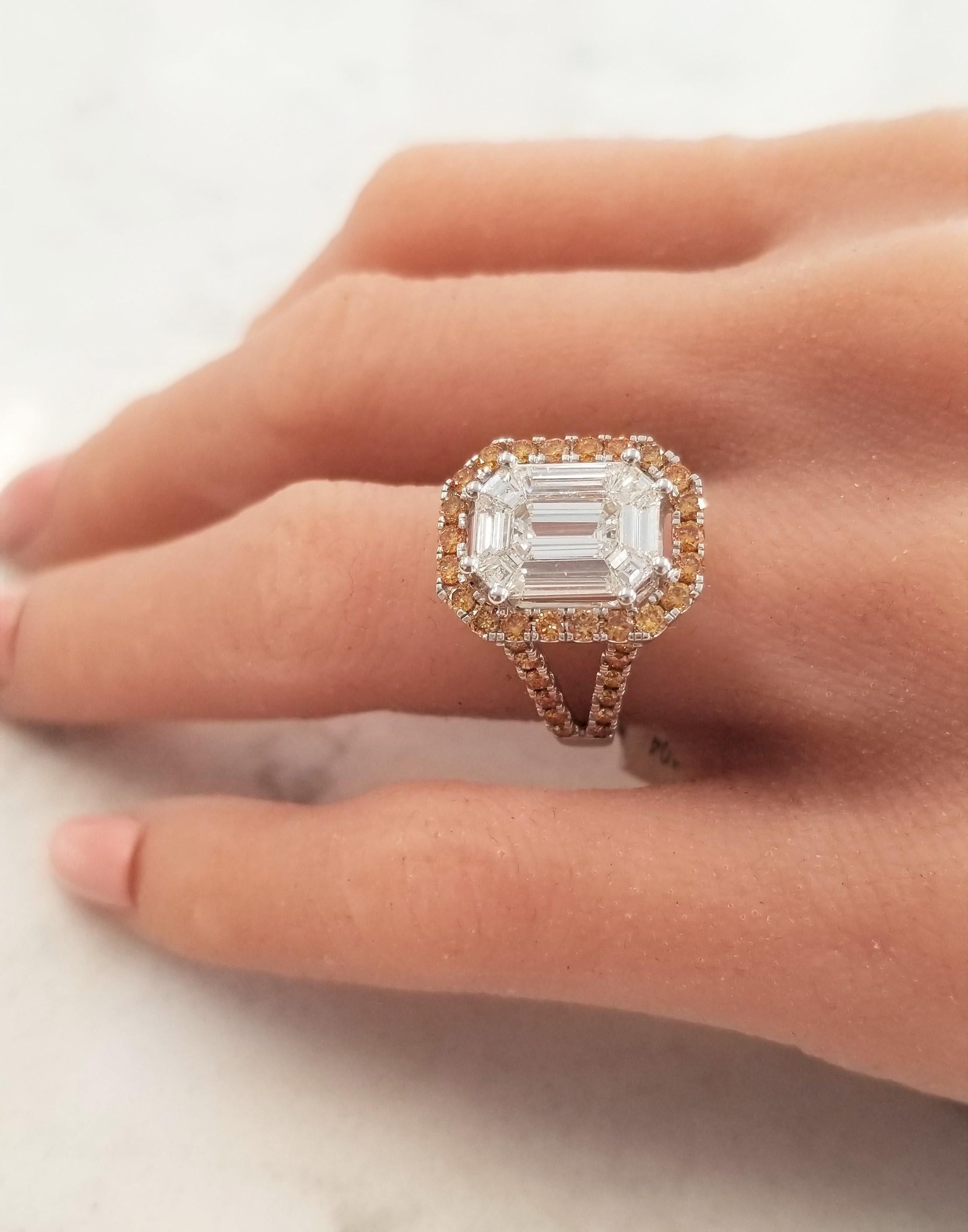 This is an illusion set ring. An emerald cut diamond is double prong set in the center, 9 step-cut trapazoid diamonds surround the emerald cut totaling for 3.70 carats. Together, the white diamonds measure 12.26x9.03mm. 0.30 carats of round