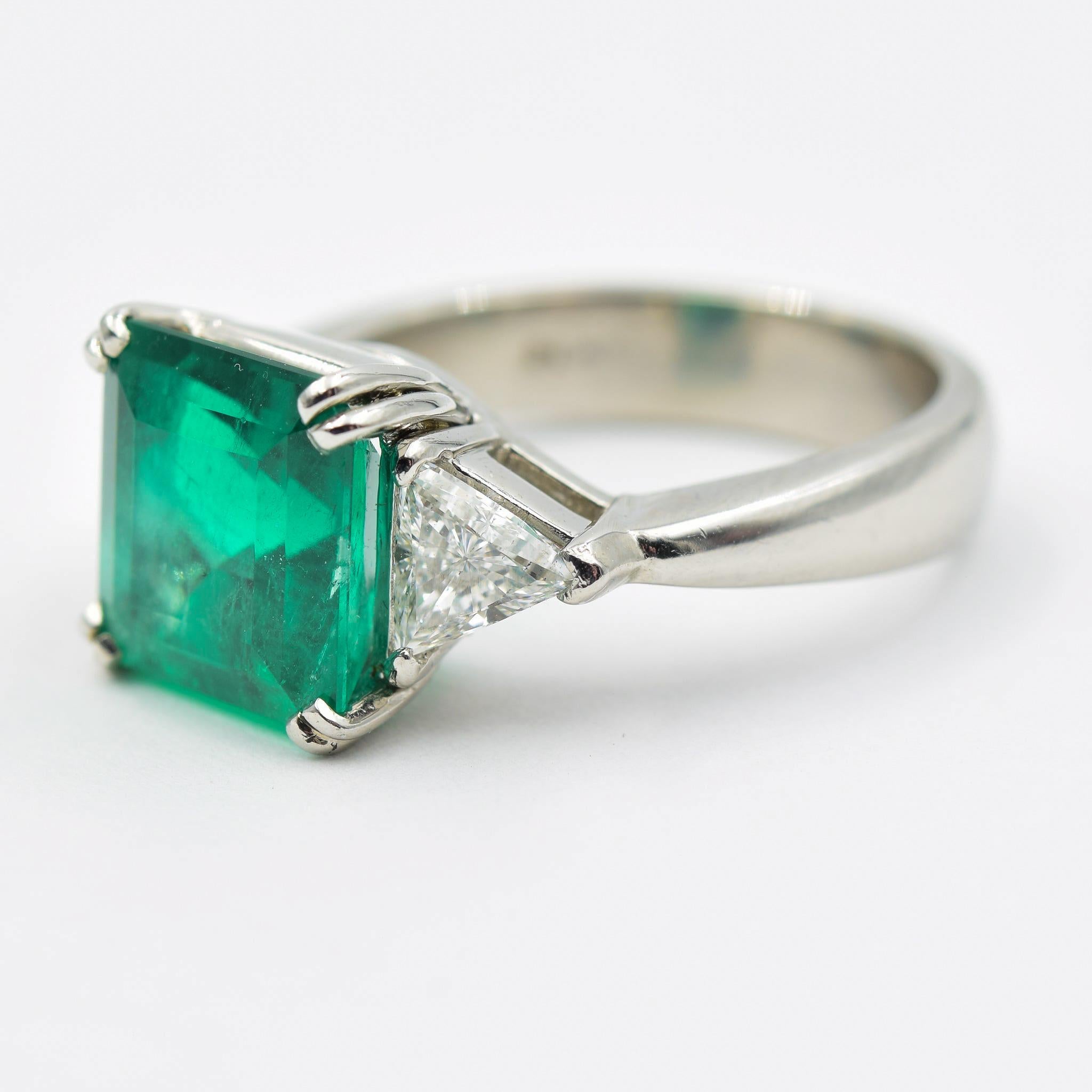 This classic emerald ring has a 3.70 carat center emerald and a trillion cut diamond on each side. This lovely piece is crafted in platinum and the emeralds are a nice quality hosting some inclusions. 
 For the value of a 3.70 carat emerald with