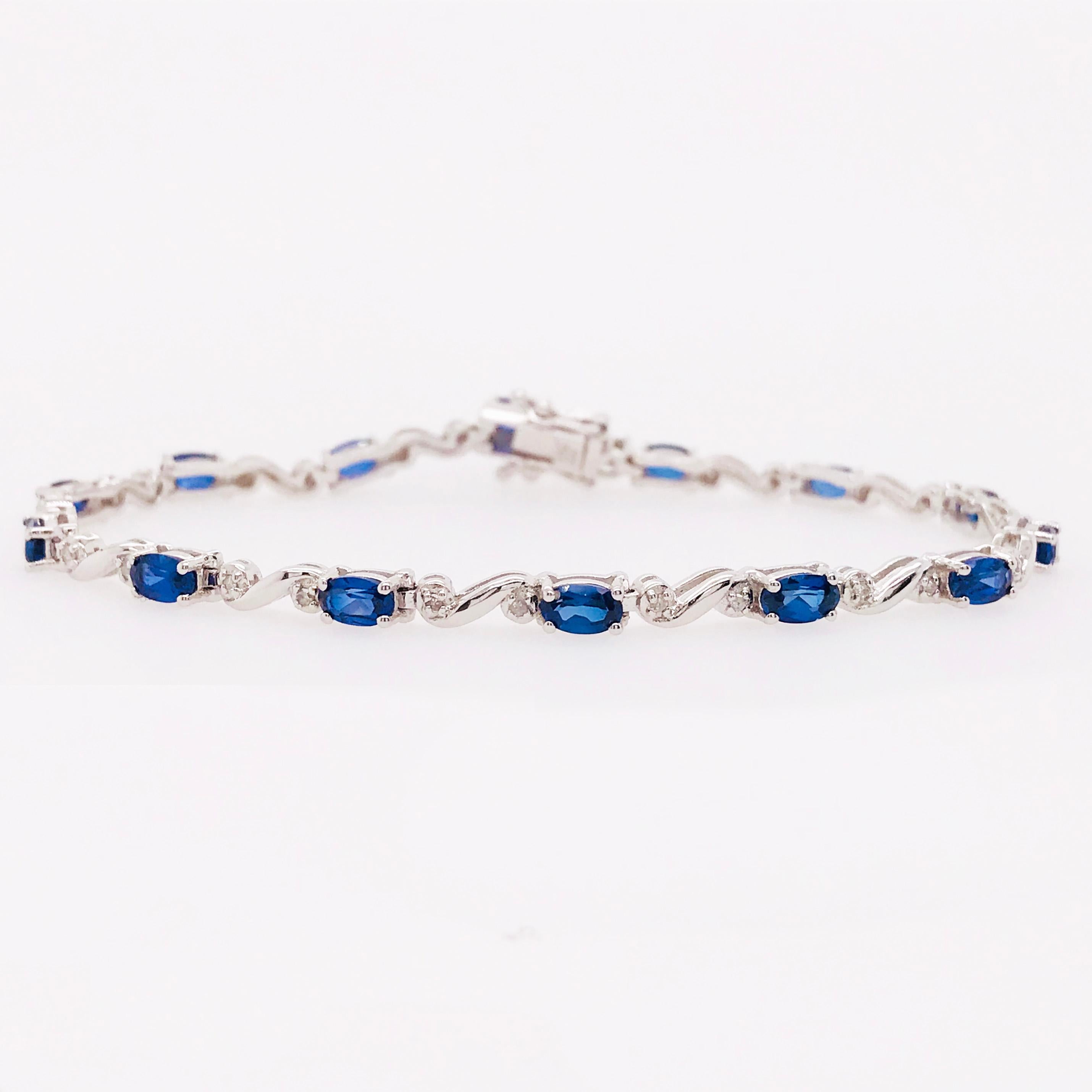 This is a traditional tennis bracelet with genuine blue sapphire gemstones and natural round brilliant diamonds. With oval blue sapphires set in between a whimsical  14K white gold diamond design. Each sapphire has been hand picked to match the