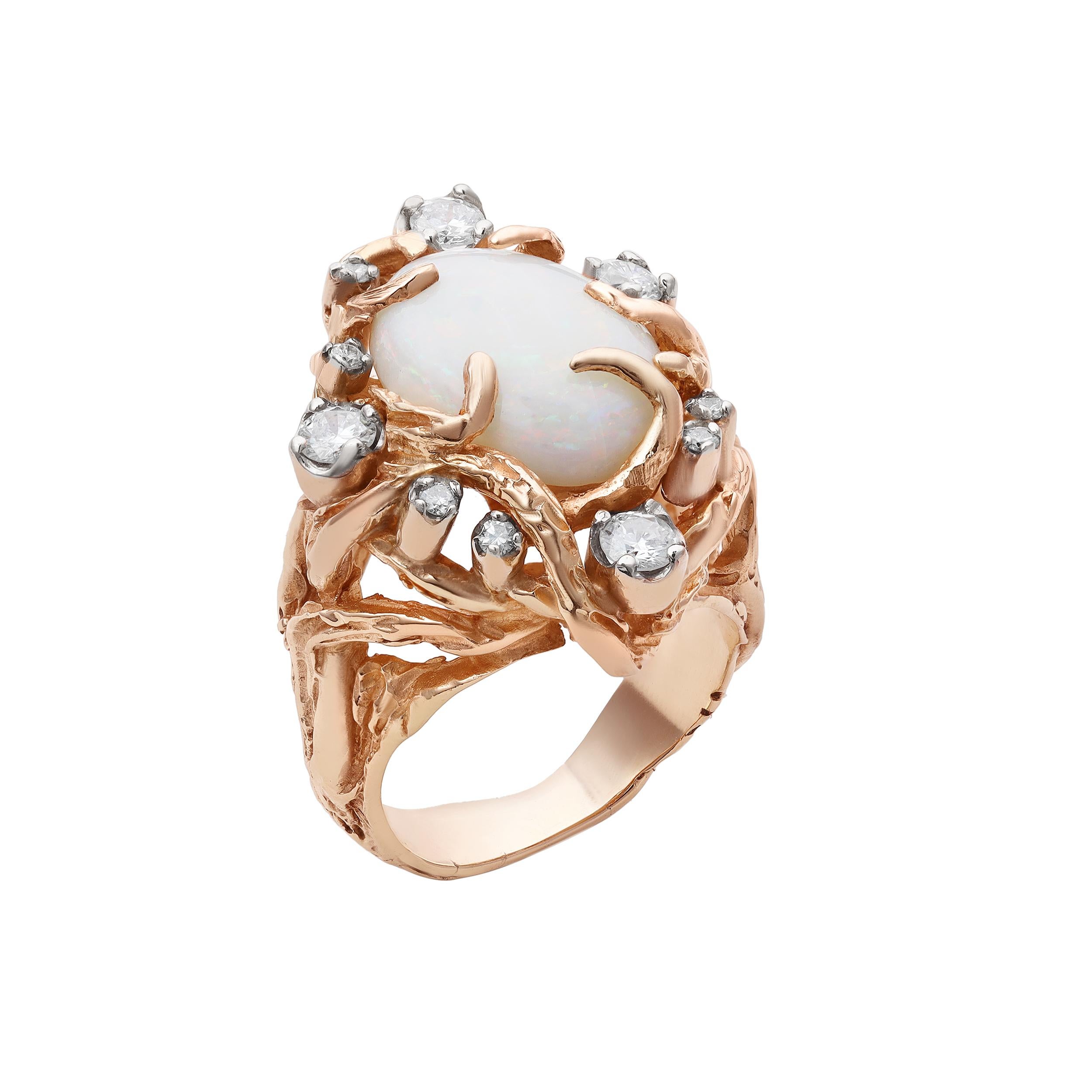 Precioso anillo de cóctel de los años 70, con un ópalo blanco etíope cabujón de 3,70 quilates, engastado en un exclusivo engaste de forma libre. Acentuada por diamantes redondos de talla brillante, con un peso total de 0,72 quilates, salpicados