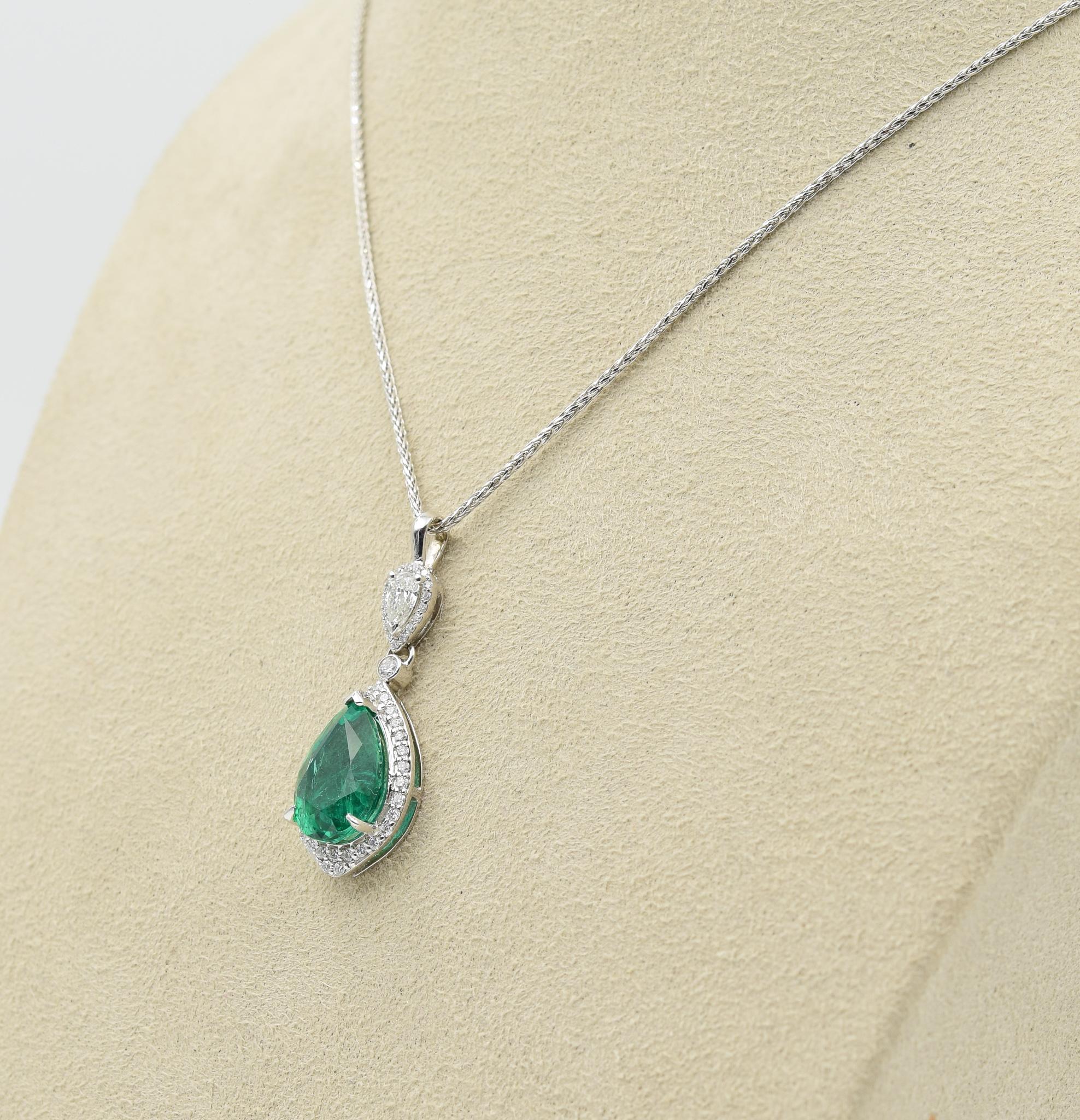 This gorgeous drop pendant has a 3.71 carat center fine quality emerald center-stone and is adorned with high-quality white diamonds. It is crafted in 18k white gold with dazzling diamonds with a sparkle you can't miss. This piece is simple but