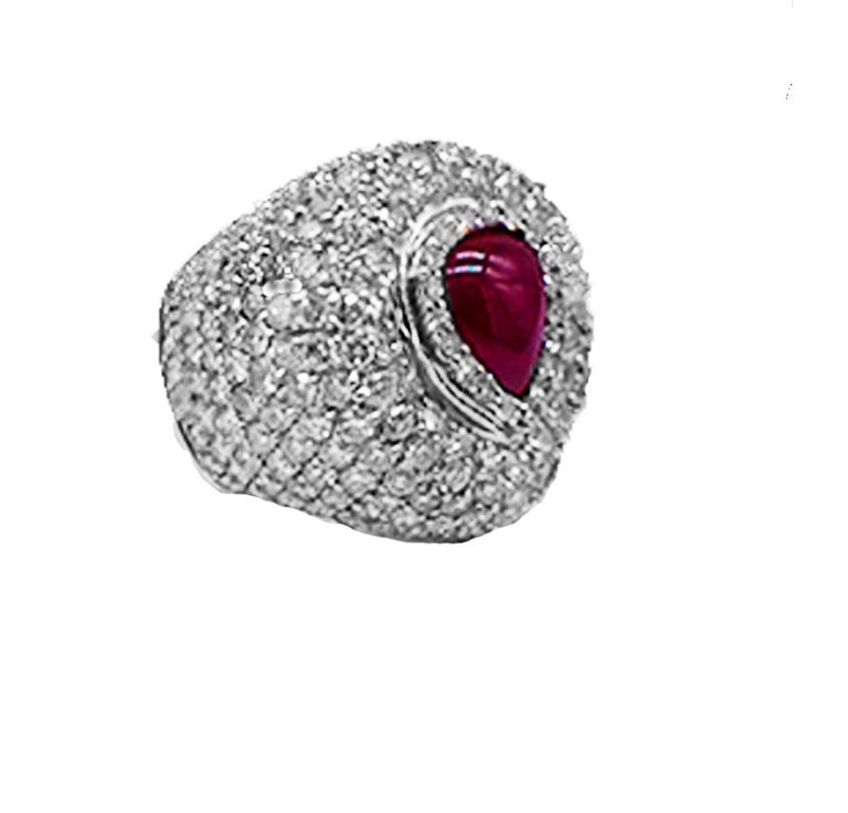 Quality designer Ruby and Dome Ring with made in 18 Karat white gold with a bezel set ruby surrounded in a dome of diamonds. The ring encompasses a large diameter and is set with quality diamonds.

The ruby is a pear-shaped cabochon cut and measures