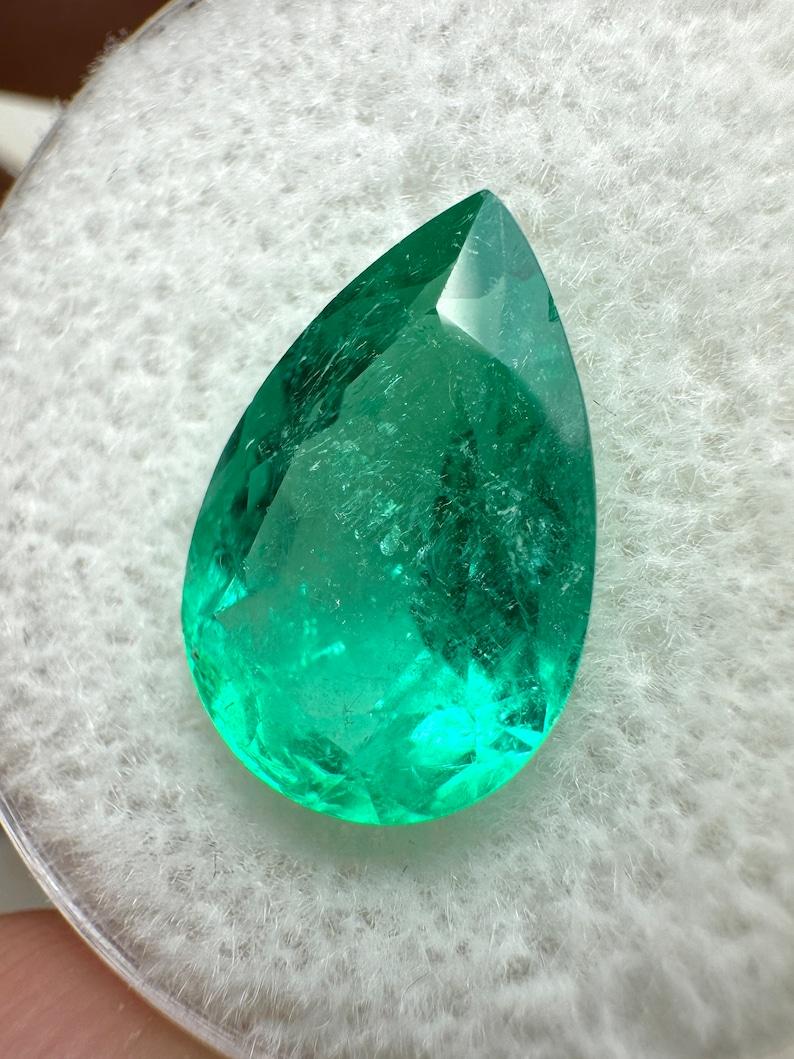 A. Stone: Smeraldo
Peso: 3,72 carati
Forma: Taglio a pera
Chiarezza: Trasparente
Lucentezza: Eccellente-Molto buona
Colore: Verde medio giallastro
Misure: 12,80 mm x 8,56 mm x 5,93 mm
Origine geografica: Colombia
Trattamento: Naturale,