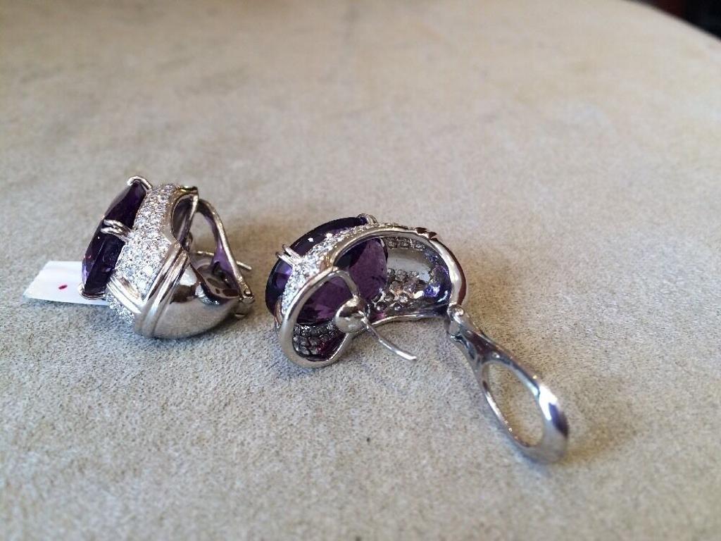 Large Oval Amethyst and Pave Diamond Earrings in 18K White Gold Total Weight 37.26 carats

Amethyst and Diamond Earrings feature two very lively, Oval-shaped Amethysts with Medium Dark Purple color and 132 Round Brilliant Diamonds pave set along the