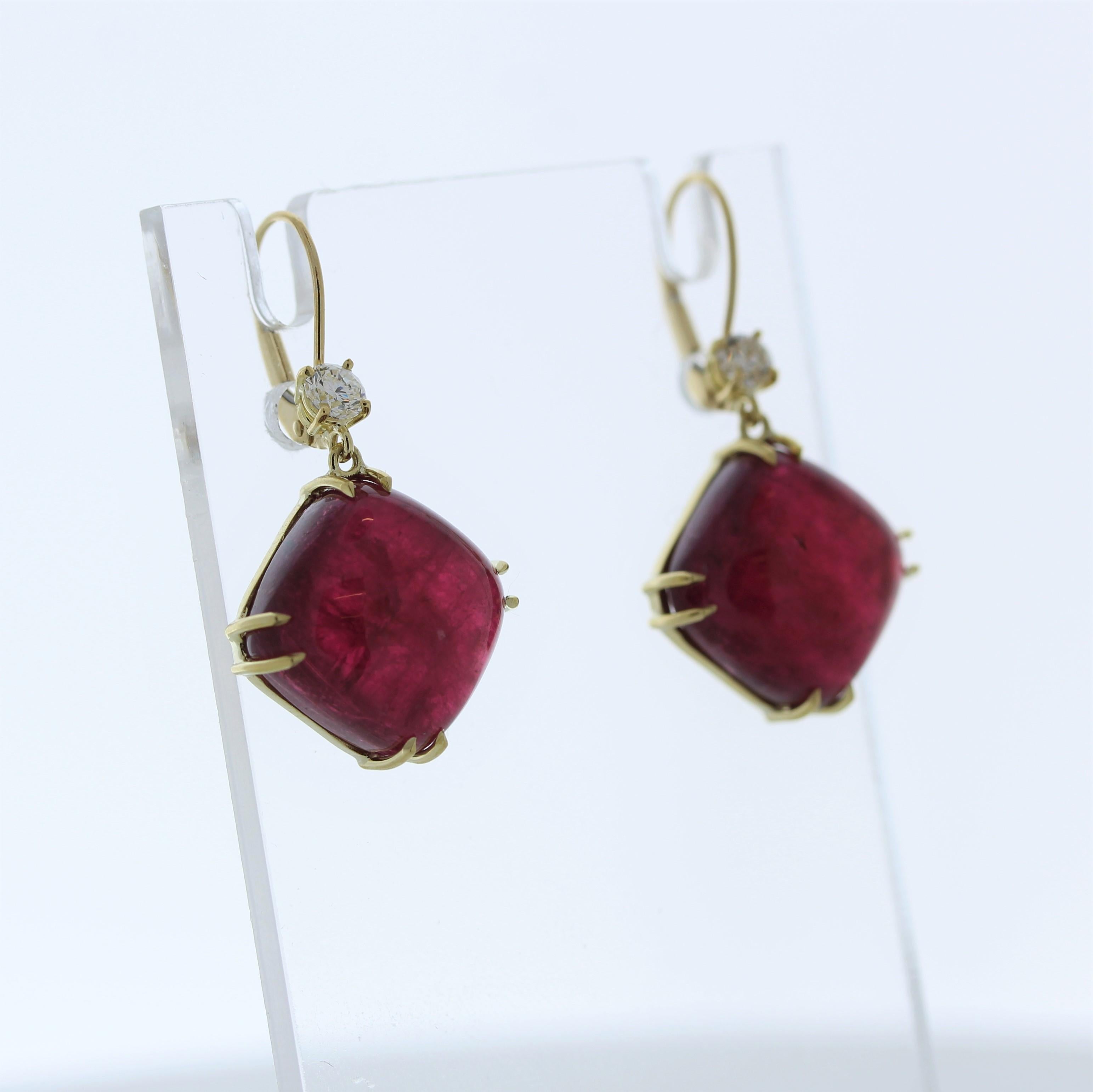 The fashion earrings feature two cabochon-cut rubelite gemstones, each weighing a total of 31.32 carats, set in 18 karat yellow gold. They are accented by a total of four round-cut diamonds with a combined weight of 0.44 carats in both earrings.