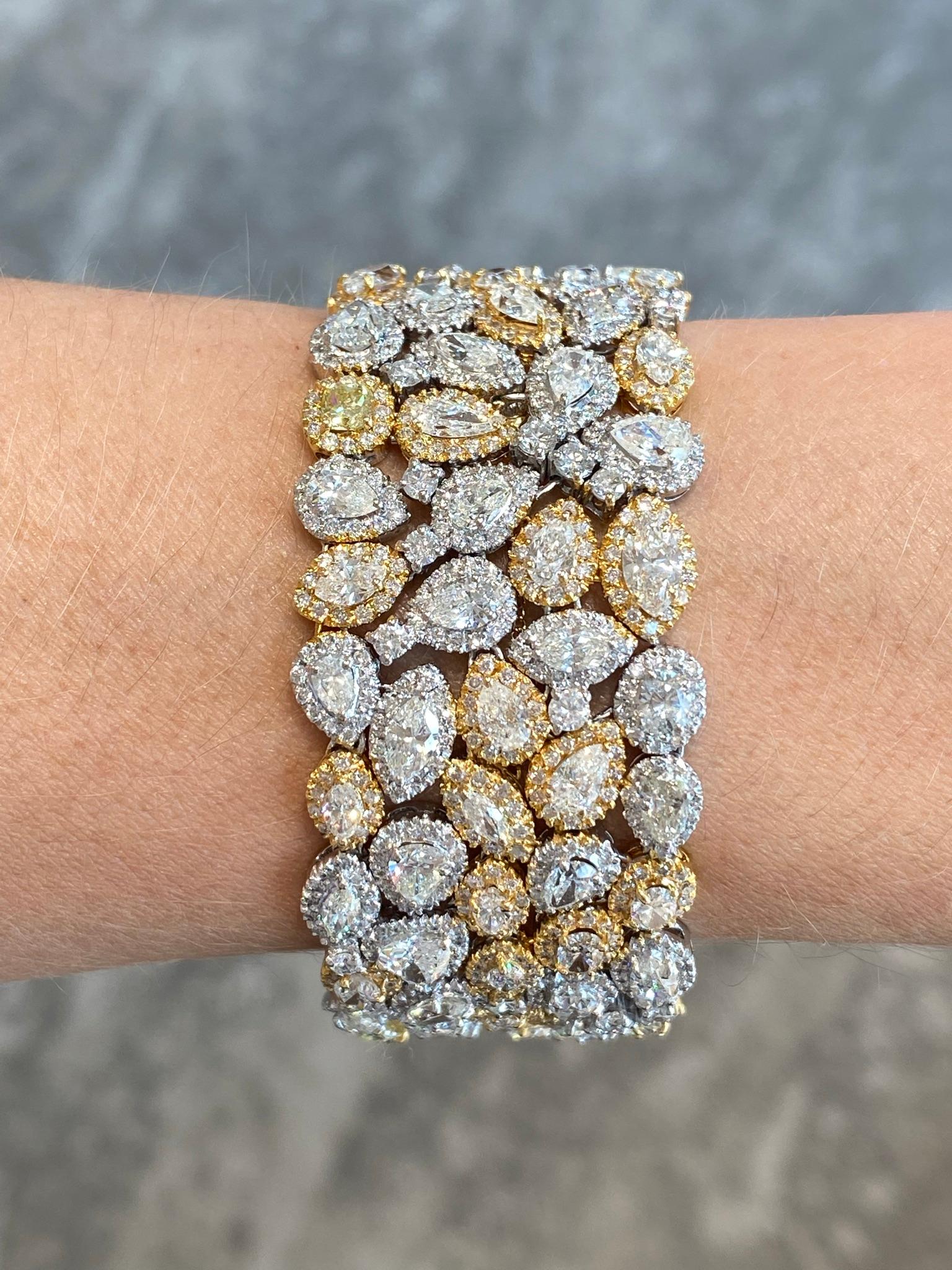 Exquisite lady's bracelet in 18KT white and yellow gold diamond bracelet featuring a rare collection of multi shaped diamonds each set in their own custom created link all independently connected and pave set with round full cut brilliant diamonds