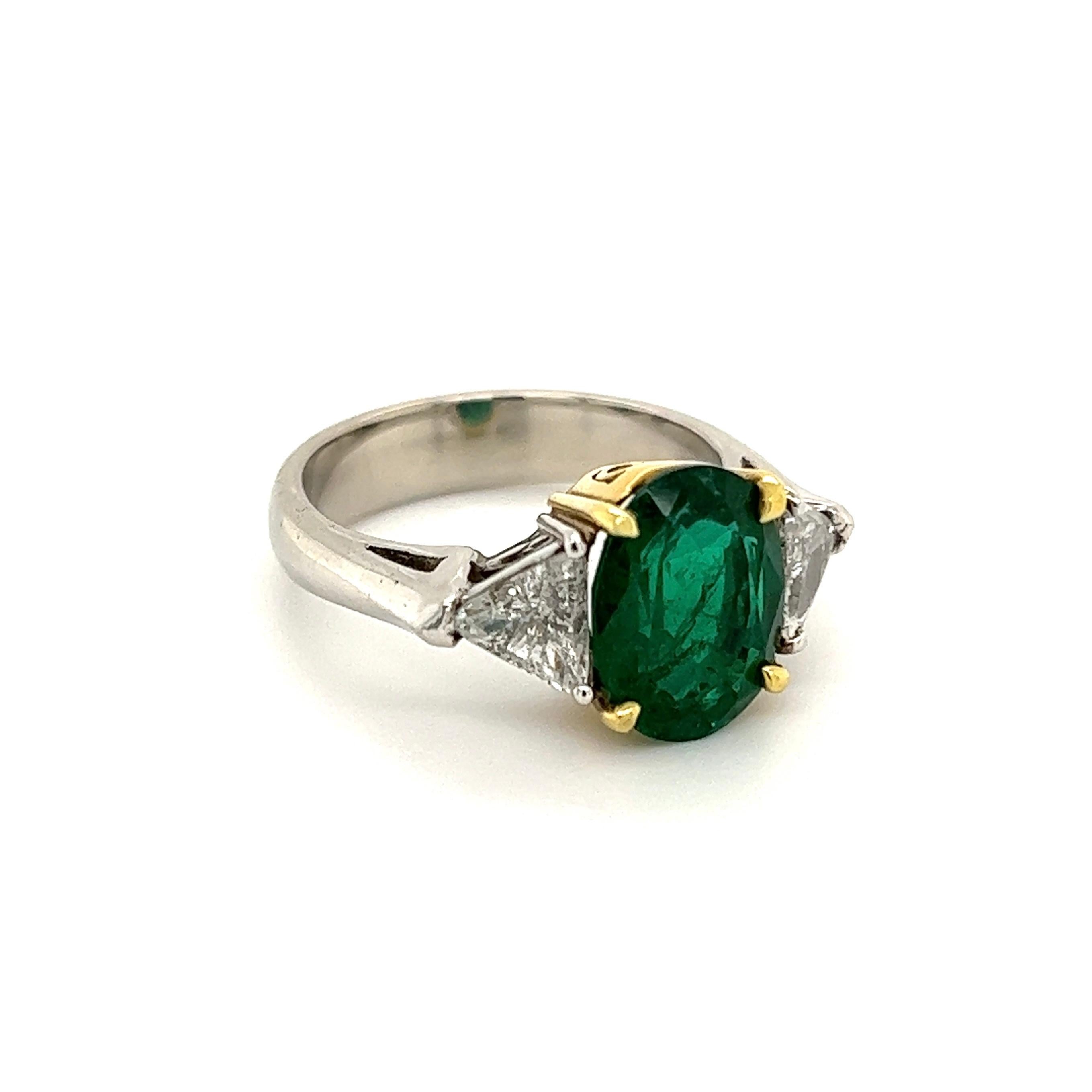 Simply Beautiful! Elegant and finely detailed Art Deco Revival 3-Stone Platinum Ring, center securely nestled Hand set with a securely nestled Oval Emerald, weighing approx. 3.74 Carats with a Trillion Diamond on either side; approx. 0.63tcw. The