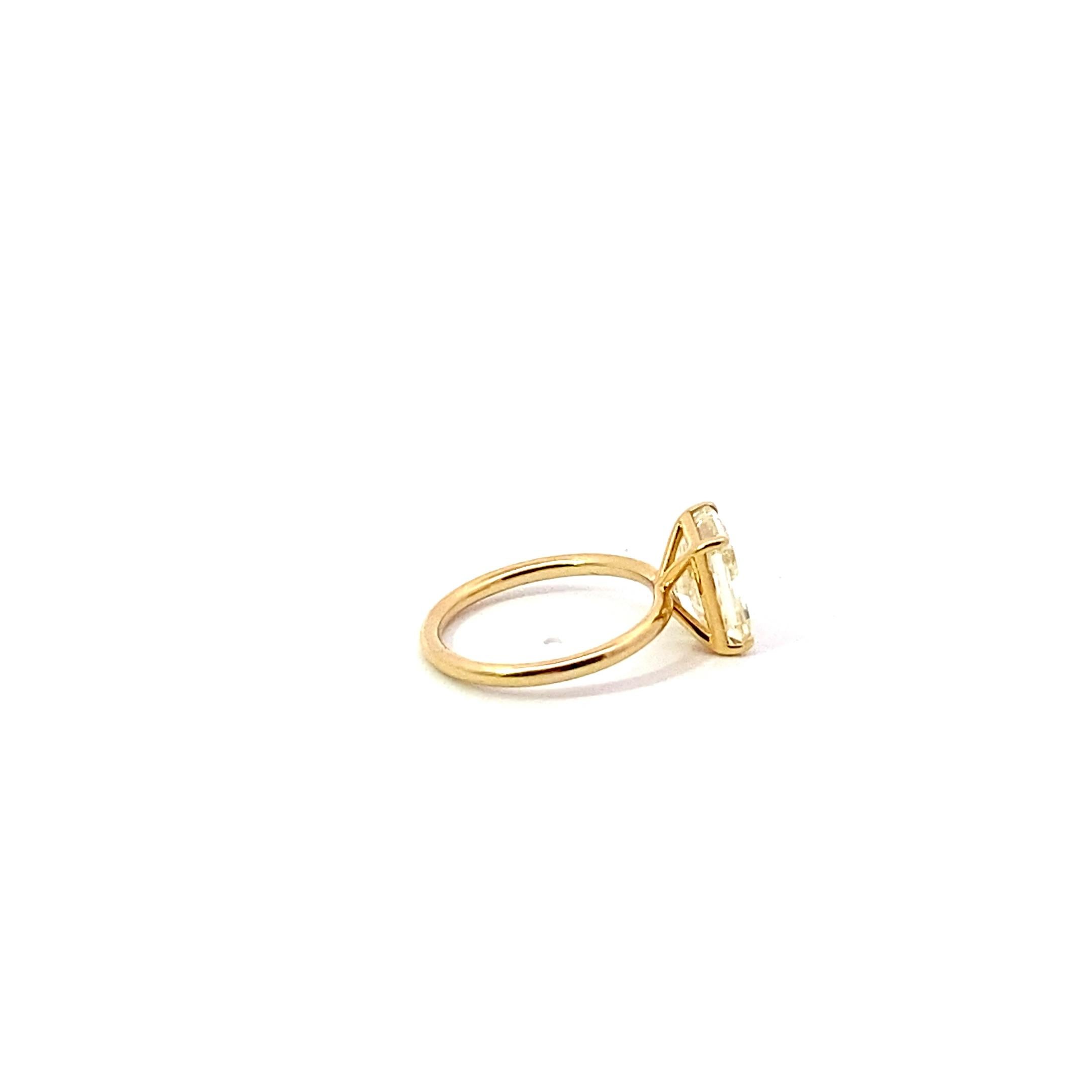 Set in 18 Karat Yellow Gold, weighing 3.10 grams, is a 3.74 carat Radiant Cut Fancy Light Yellow diamond, Clarity Grade of: VVS-1. Size 6. Wisper thin setting. 

