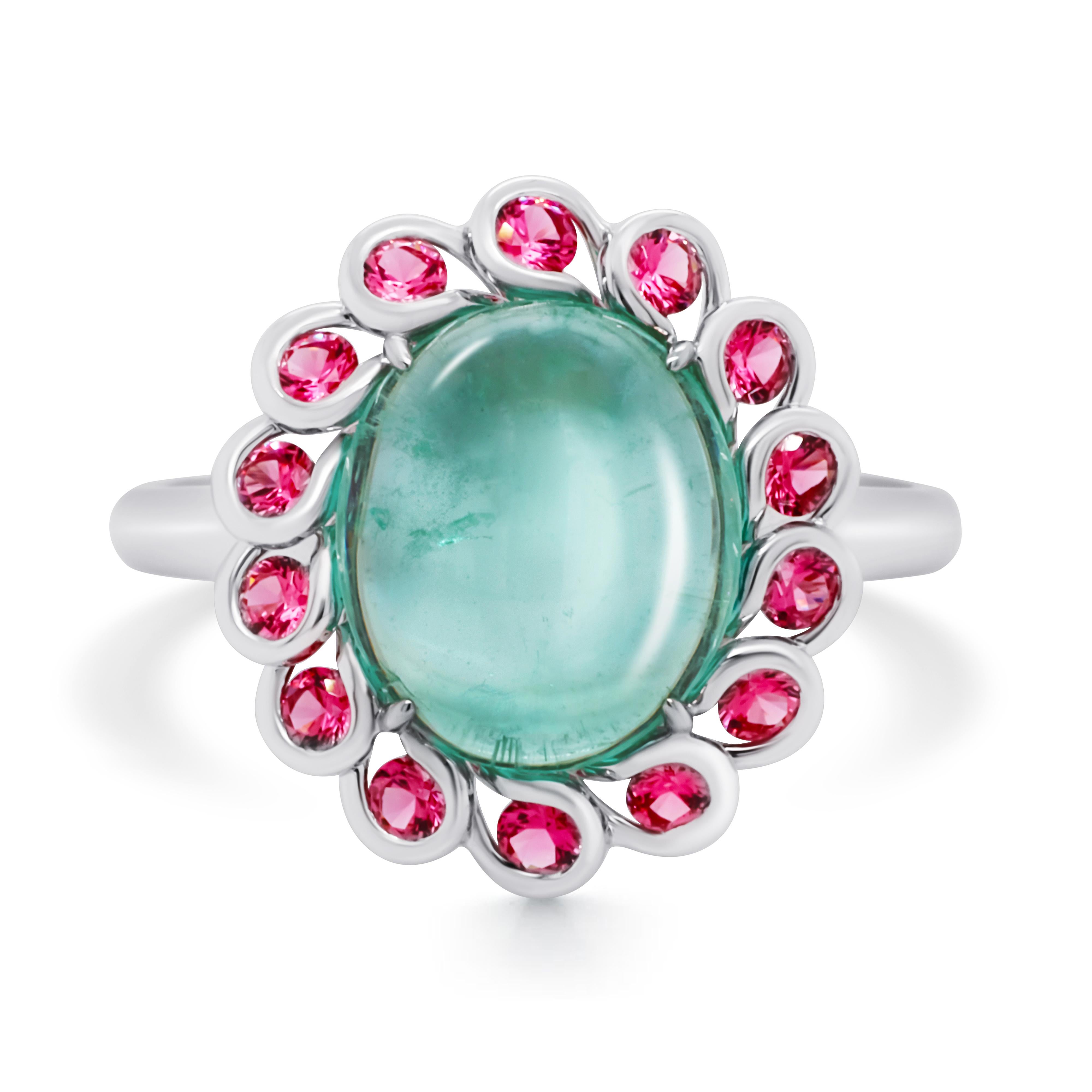 A playful Ring centered with mint green Emerald cabochon and accented by romantic pink Spinel. 
The Emerald comes from the picturesque Ural Mountains in Russia and has a very pleasant green color. The Spinels set around the Emerald are nice pink