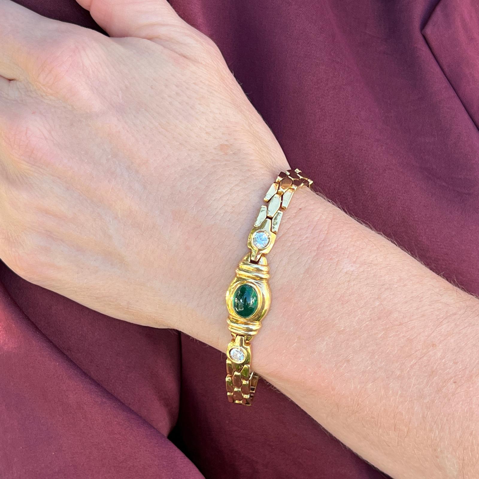 Emerald and diamond link bracelet fashioned in 18 karat yellow gold. The bracelet features an approximately 3.75 carat oval cabochon emerald flanked by 2 round briliant cut diamonds weighing .50 carat total weight. The diamonds are graded G-H color