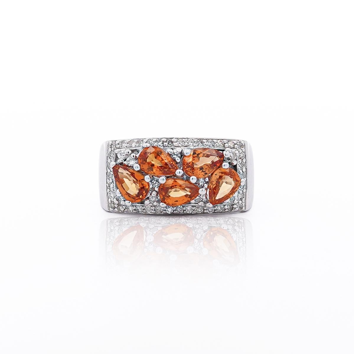 Questo splendido anello vintage presenta uno zaffiro arancione a forma di pera da 3,75 carati, elegantemente incastonato in oro bianco 14 carati. La vibrante tonalità arancione dello zaffiro è perfettamente completata da 0,50 carati di diamanti