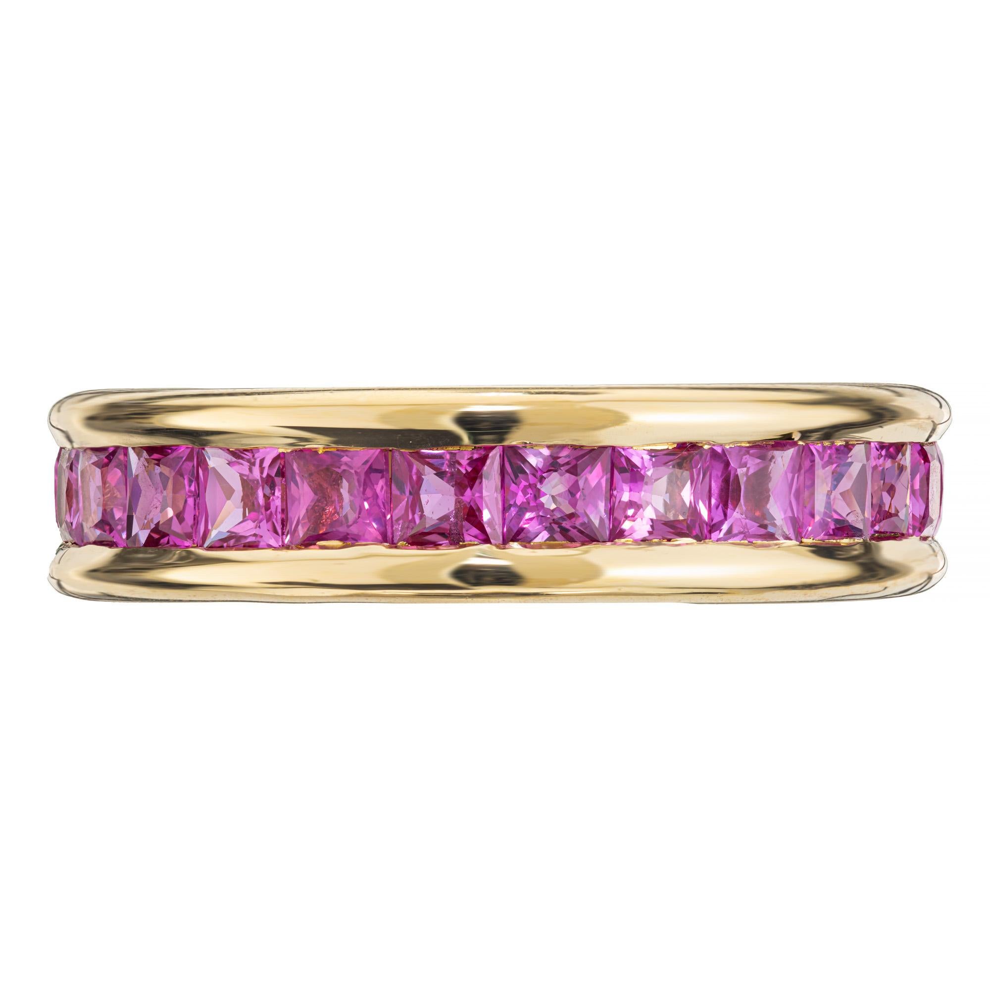 Beautiful pink sapphire wedding band ring. 18k yellow gold eternity setting with 25 channel set square cut rich pink sapphires totaling 3.75cts. The mix of pink sapphires and yellow gold makes it a spectacular piece. Please note this ring is not