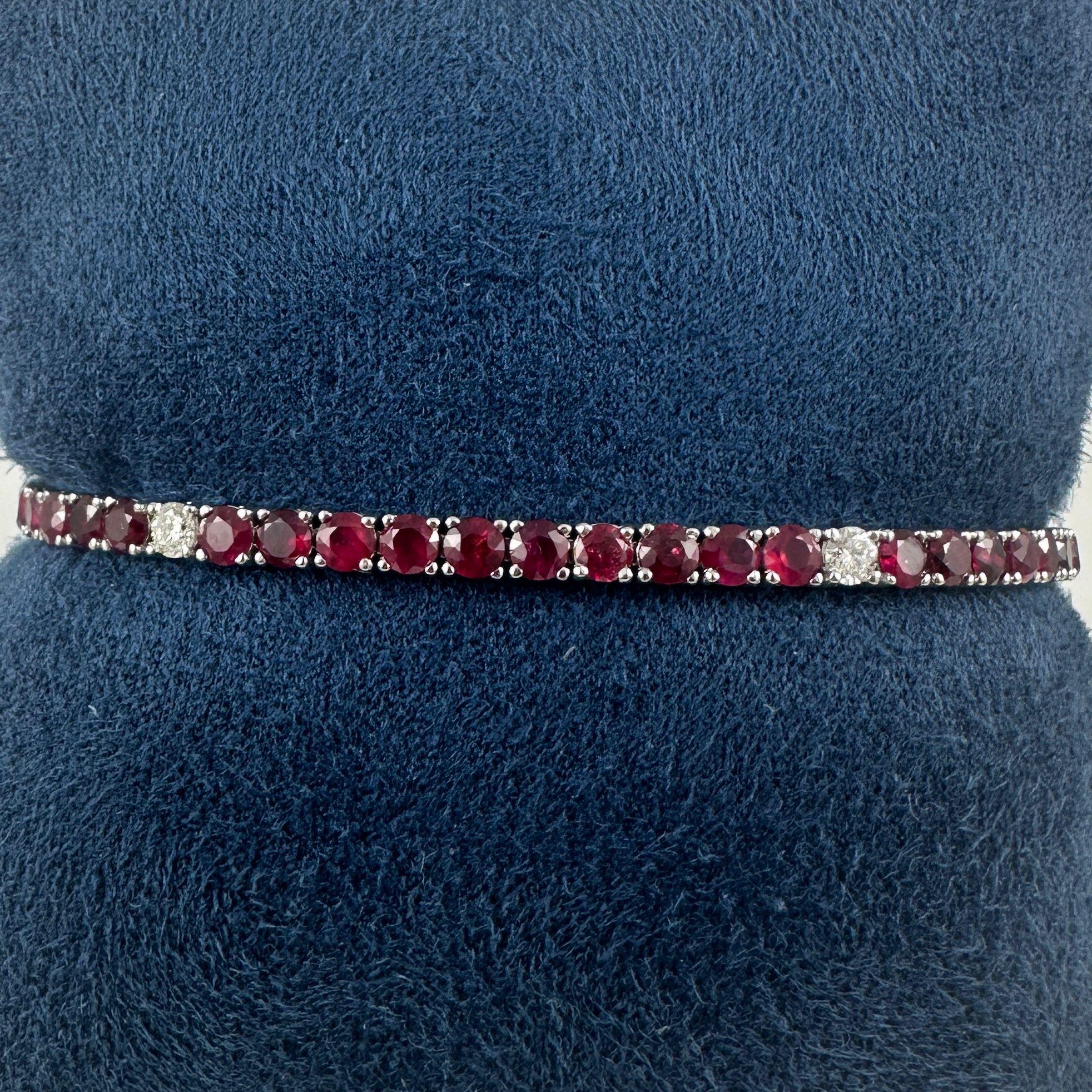 Radioso e senza tempo, questo braccialetto tennis unisce l'eleganza ardente dei rubini al classico scintillio dei diamanti. Sapientemente realizzato in oro bianco 14 carati, il bracciale presenta una linea continua di rubini a taglio rotondo in una