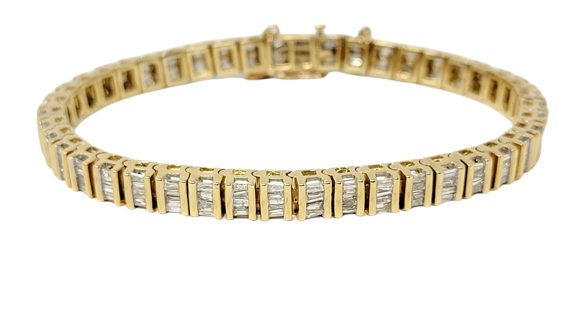 This is an absolutely beautiful diamond tennis bracelet with a sleek, contemporary design. Glittering baguette diamonds are paired with elegant 14 karat yellow gold horizontal bar links, giving a slightly modernized feel, while still remaining