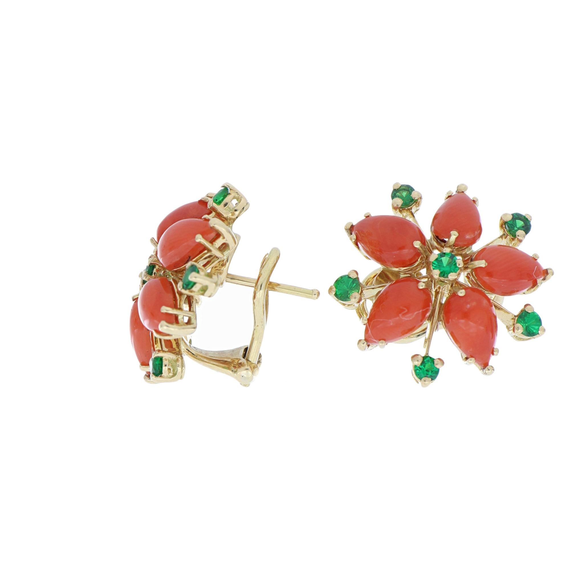 These gorgeous 18 Kt yellow gold earrings recall the wild beauty of nature. 5 corals make up the petals of these beautiful flowers that also feature round green tsavorite accent stones.
Coral bears the rather charming nick-name of “Sea’s Garden” in