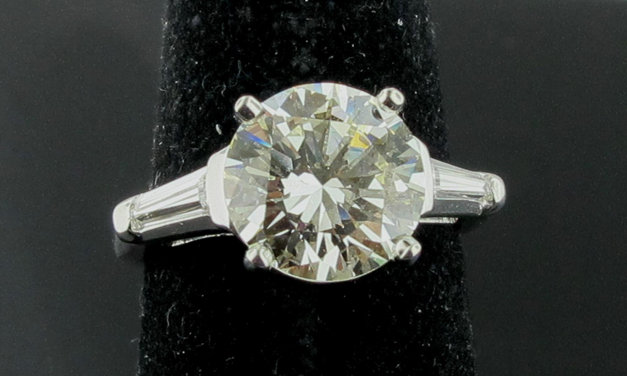 Set in Platinum is a 3.75 carat round brilliant cut diamond, Color K, Clarity VS-2.  Included are two Baguettes with a weight of 0.30 carats.  Ring size is 7. 