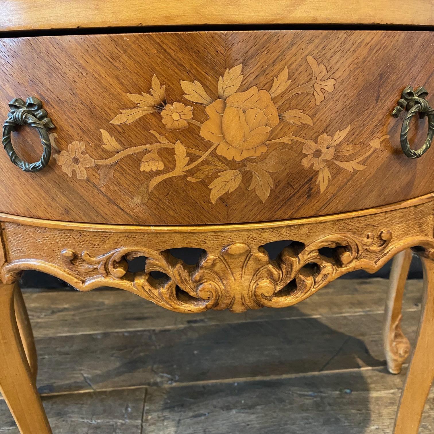Really lovely 19th century French Louis XV demilune commode with marble top and exquisite floral marquetry.   Lovely ribbon pulls and intricately carved apron with acanthus leaves and crest. Tapered cabriole legs ending in pretty escargot feet with