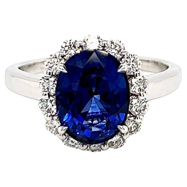 3.75 Total Carat Oval Blue Sapphire and Diamond Halo Ladies Engagement Ring For Sale