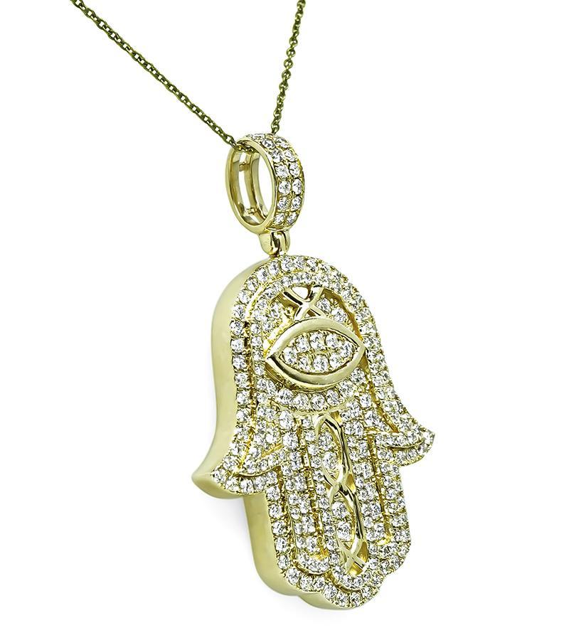This is a charming 14k yellow gold hamsa hand pendant. The pendant is set with sparkling round cut diamonds that weigh approximately 3.75ct. The color of the diamonds is G with VS clarity. The pendant measures 53mm by 34mm and weighs 16.1 grams.