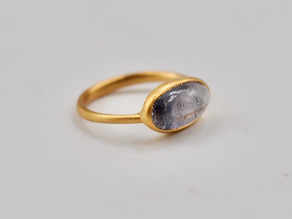 This simple ring by Scrives is composed of grey tourmaline cabochon of 3.76 cts.
The stone is set in a 22kt closed gold setting.
This stone is natural and has natural & typical inclusions (eye-visible). 

This ring is handmade with 22kt mat finish