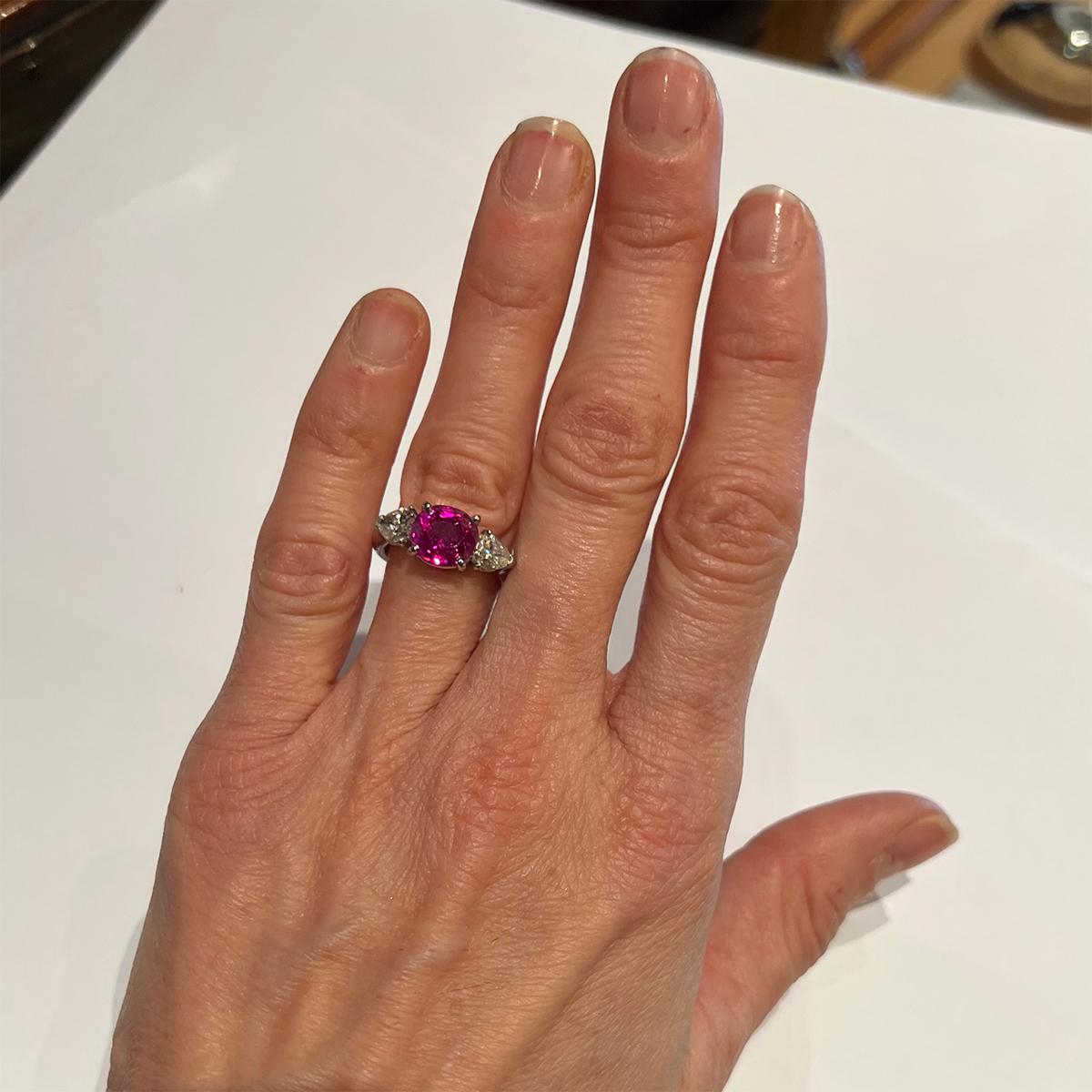 Ruby and diamond three-stone ring, centering an oval, mixed-cut natural Burmese ruby weighing 3.76 carats flanked by two pear-shaped diamonds totaling approximately 2.50 carats. Handmade platinum mounting with 14kt white gold shank marked 