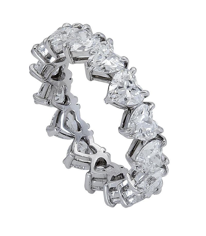 A delicate and chic eternity wedding band style showcasing a row of brilliant heart shape diamonds set in platinum. Diamonds weigh 3.77 carats total. Can be used as a fashion ring as well. Size 6.25 US.