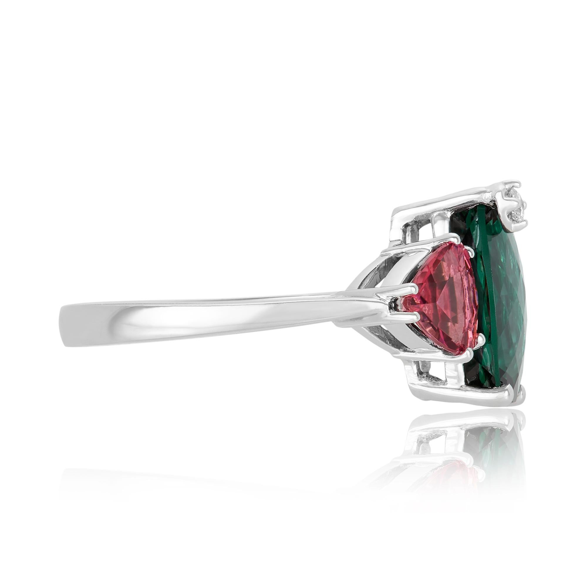 Metal: 14K White Gold
Center Stone: 1 Green Tourmaline 3.78 ct - Measuring 11.5 x 9.8 mm
Side Stones: 2 Trillion Shaped Pink Tourmalines at 1.17 ct- Clarity: SI
Diamond Details: 1 Round White Diamond at 0.03 Carats- Clarity: SI / Color H-I
Ring