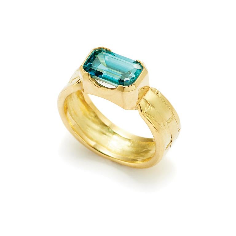 An emerald cut Fine Blue Zircon is set in an 18 Karat Gold basket weave design band.

Blue Zircon: 3.79 Carat