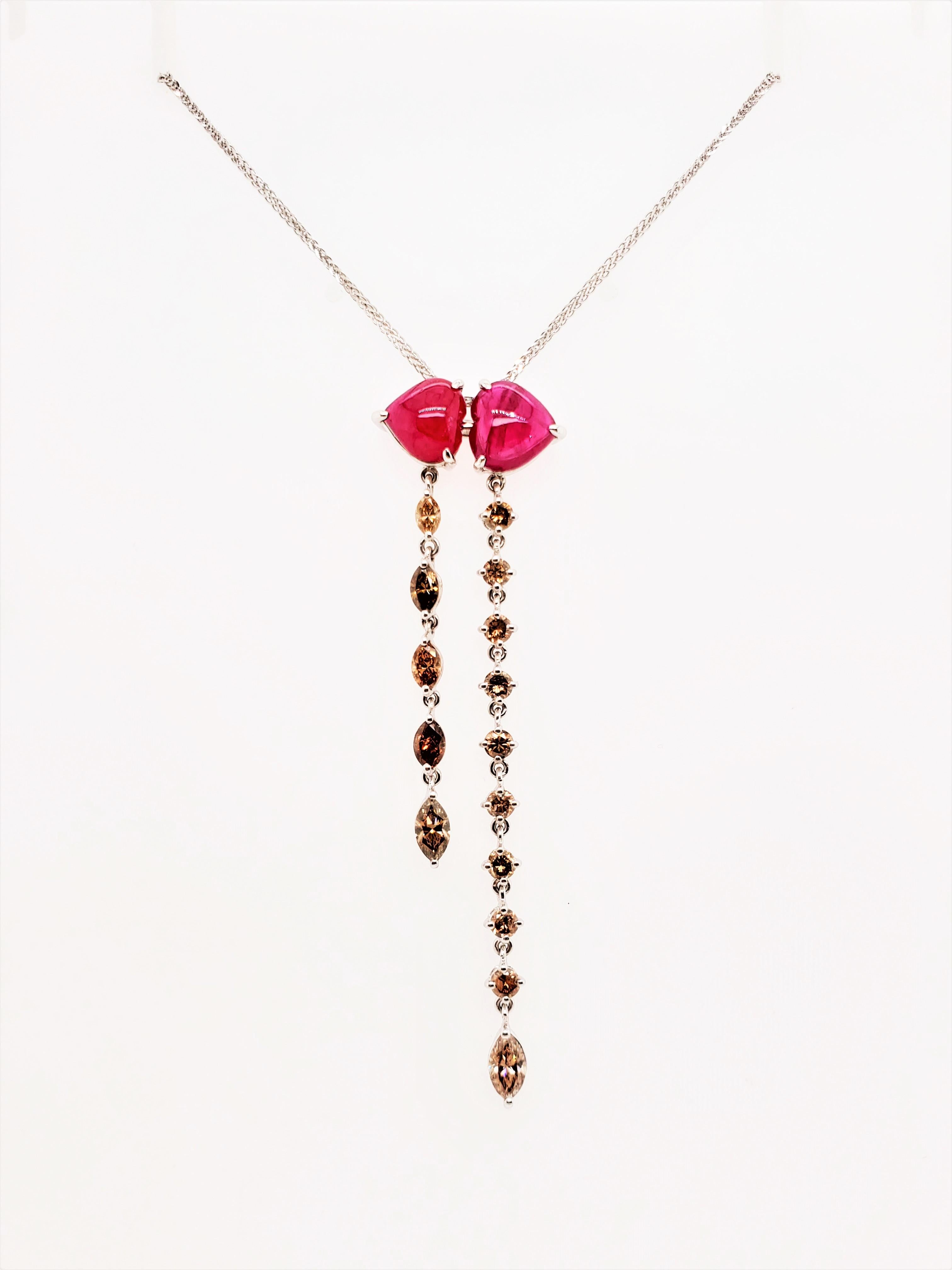 3.79 Carat Ruby Cabochon And Brown Diamond White Gold Pendant With Gold Chain:

A magnificent pendant necklace comprised of two luscious red heart-shaped cabochon rubies weighing 3.79 carat, with flowing brown diamond lines weighing 1.81 carat. The