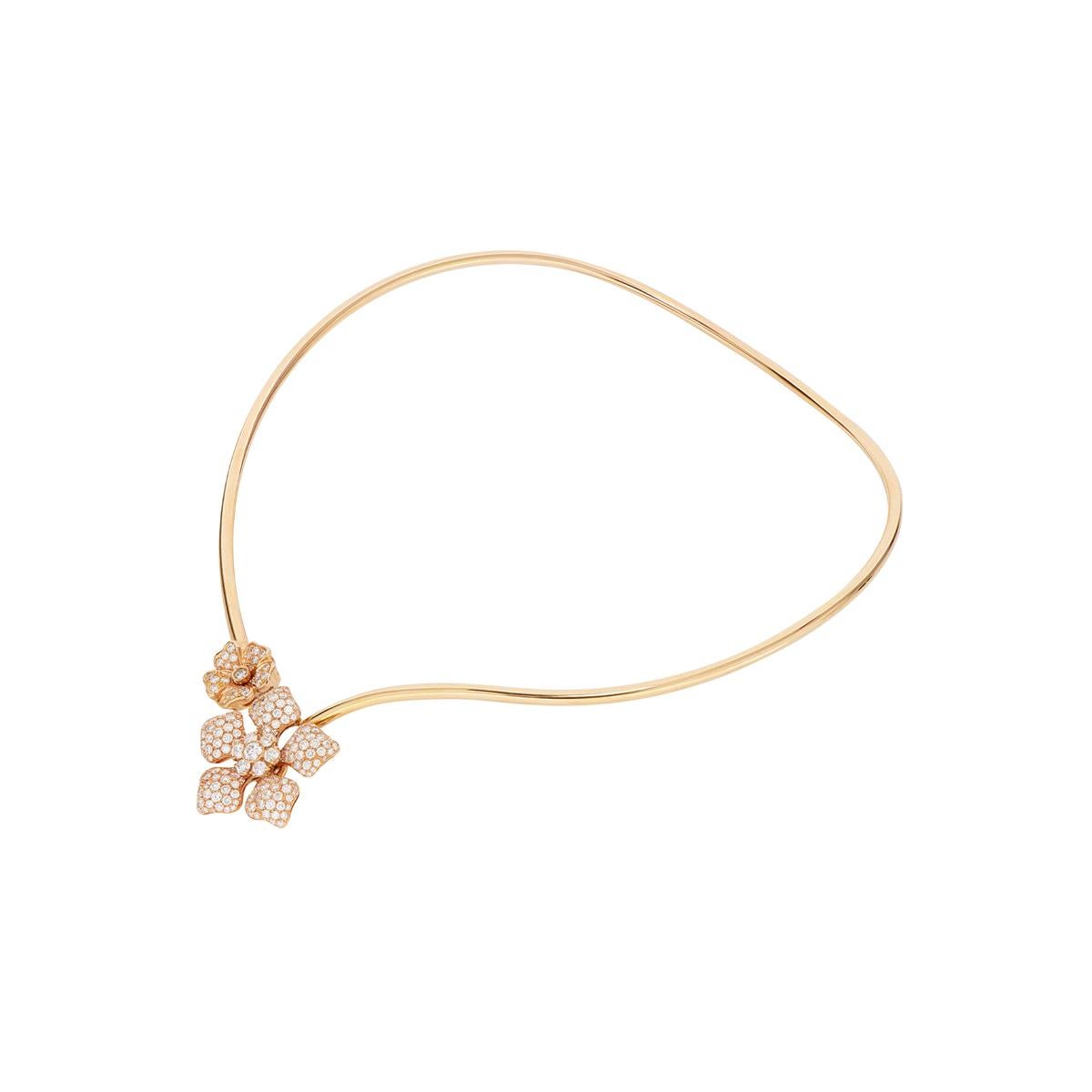 This adjustable diamond flower necklace is feminine and fashionable at the same time. The 18 Kt rose gold asymmetrical collar features two flowers of different sizes and shapes on its ends. Both are beautifully covered in white diamonds for a