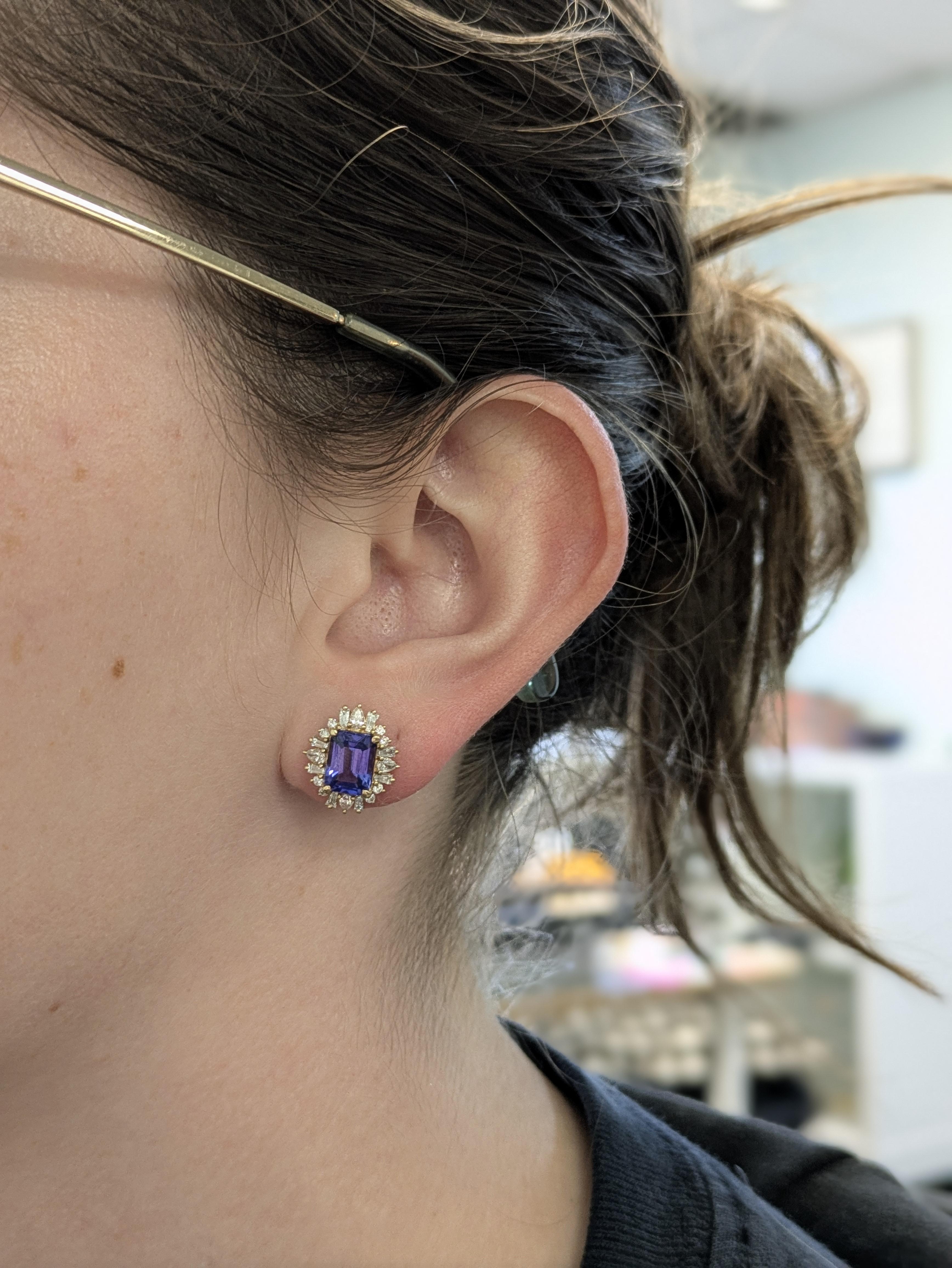 Un paio di squisiti orecchini in oro 14K con centri di tanzanite taglio smeraldo (da ~2 a 3,79 carati in totale, circa 8×6 mm), provenienti dalla Tanzania. Sono splendidamente incorniciati da 40 diamanti, con un peso complessivo di circa 0,83