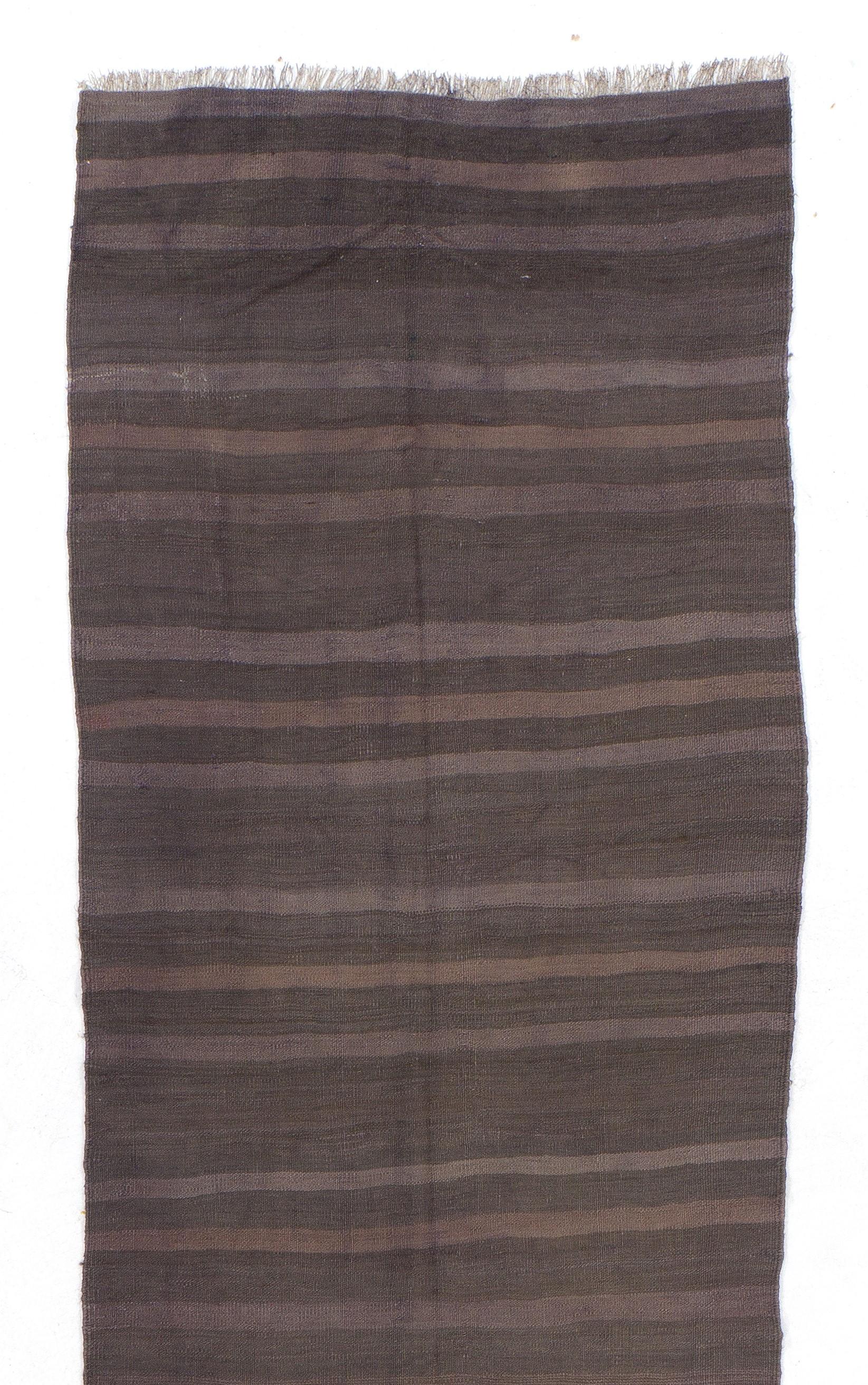 A vintage striped flat-woven handmade kilim runner rug from Turkey, made of un-dyed organic sheep's wool in shades of taupe and brown. 

It is in good condition with no issues, lightweight, reversible and professionally washed. We can also supply a