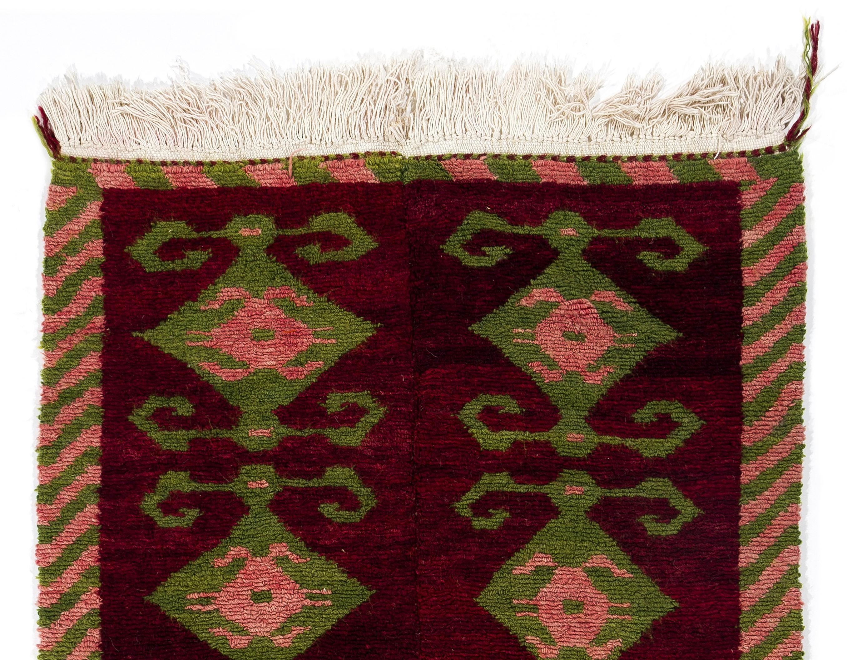 A vintage hand knotted Tulu (thick piled) rug from Konya in Central Turkey. The rug is made of hand-spun lamb’s wool, is very soft and feels comfortable under your feet. It has a lively color palette of deep ruby red, grass green and french rose