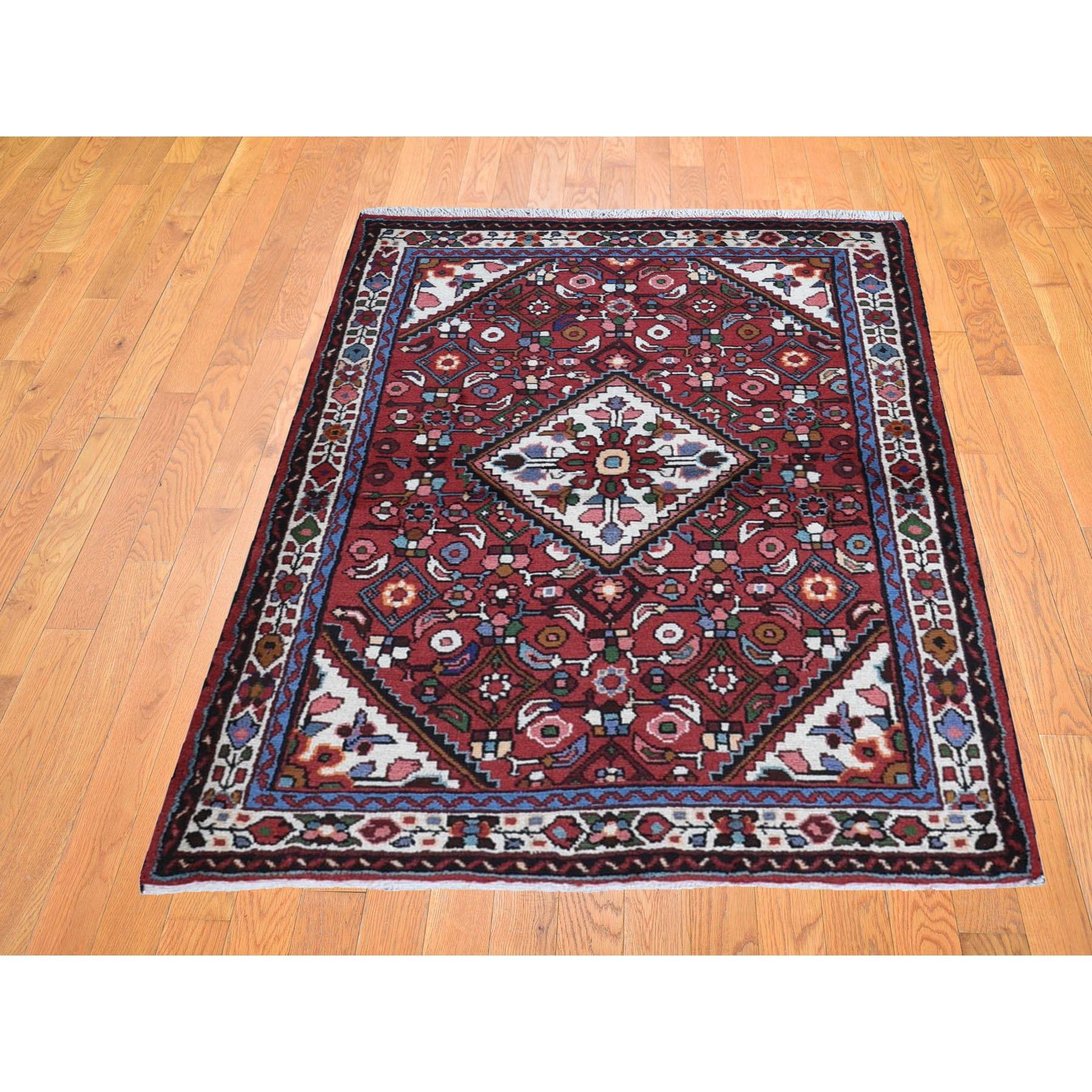 Il s'agit d'un véritable tapis oriental en pure laine nouée à la main, de style Hamadan, rouge et persan, avec un design géométrique. Il a été tissé pendant des mois et des mois selon les techniques séculaires de l'artisanat persan par des artisans