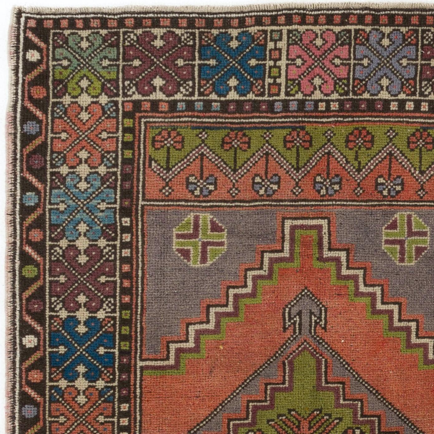 Tapis turc vintage des années 1950 finement noué à la main, présentant un motif géométrique bien dessiné avec un médaillon en son centre. Le tapis est fait de poils de laine moyens sur une base de laine. Il est lourd et repose à plat sur le sol, en