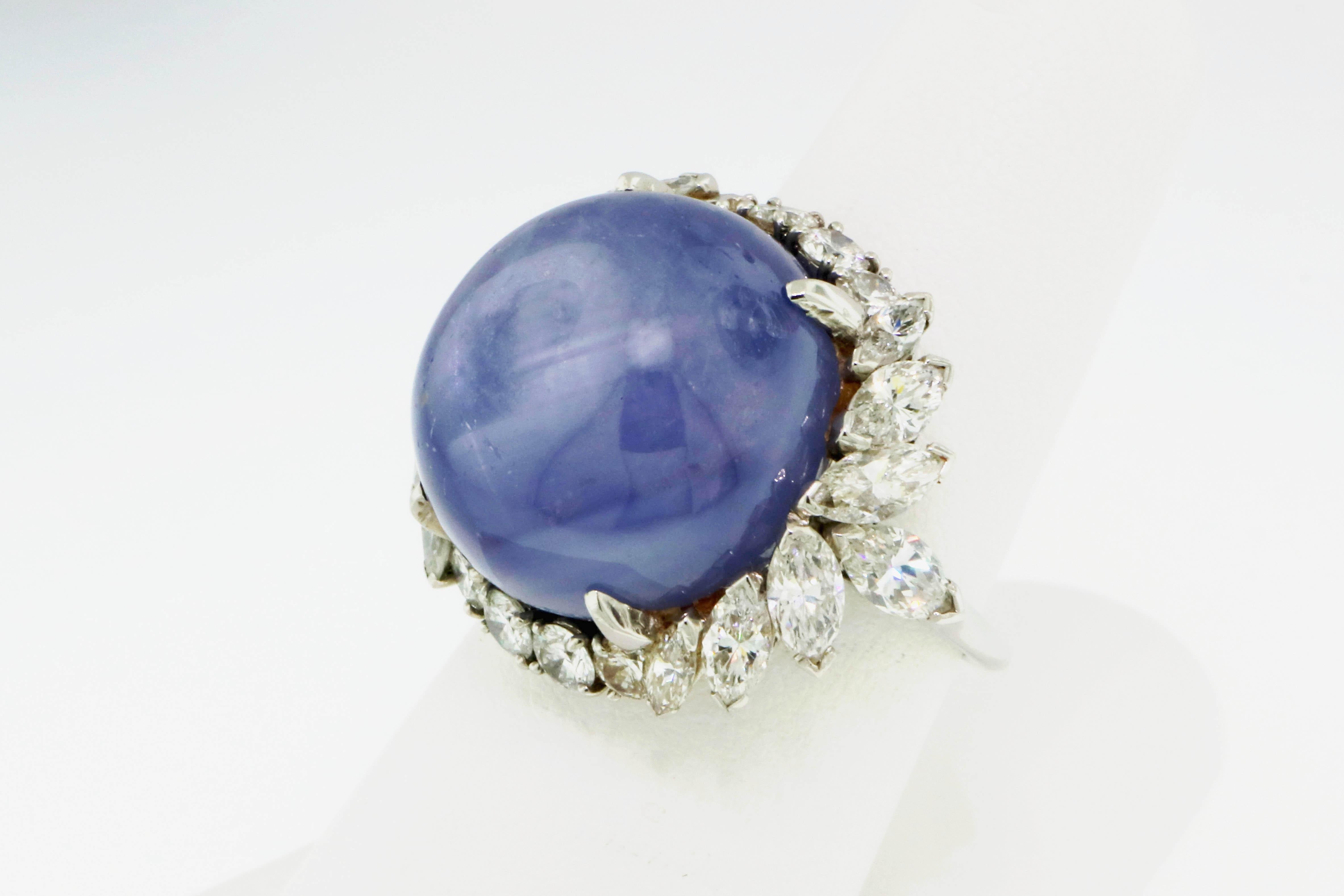 This rare star sapphire cocktail ring is an absolute showstopper. It features a stunning, high polished blueish-purple cabochon stone, surrounded by a sparkling halo of icy white diamonds. This magical stone shimmers beautifully in the light,