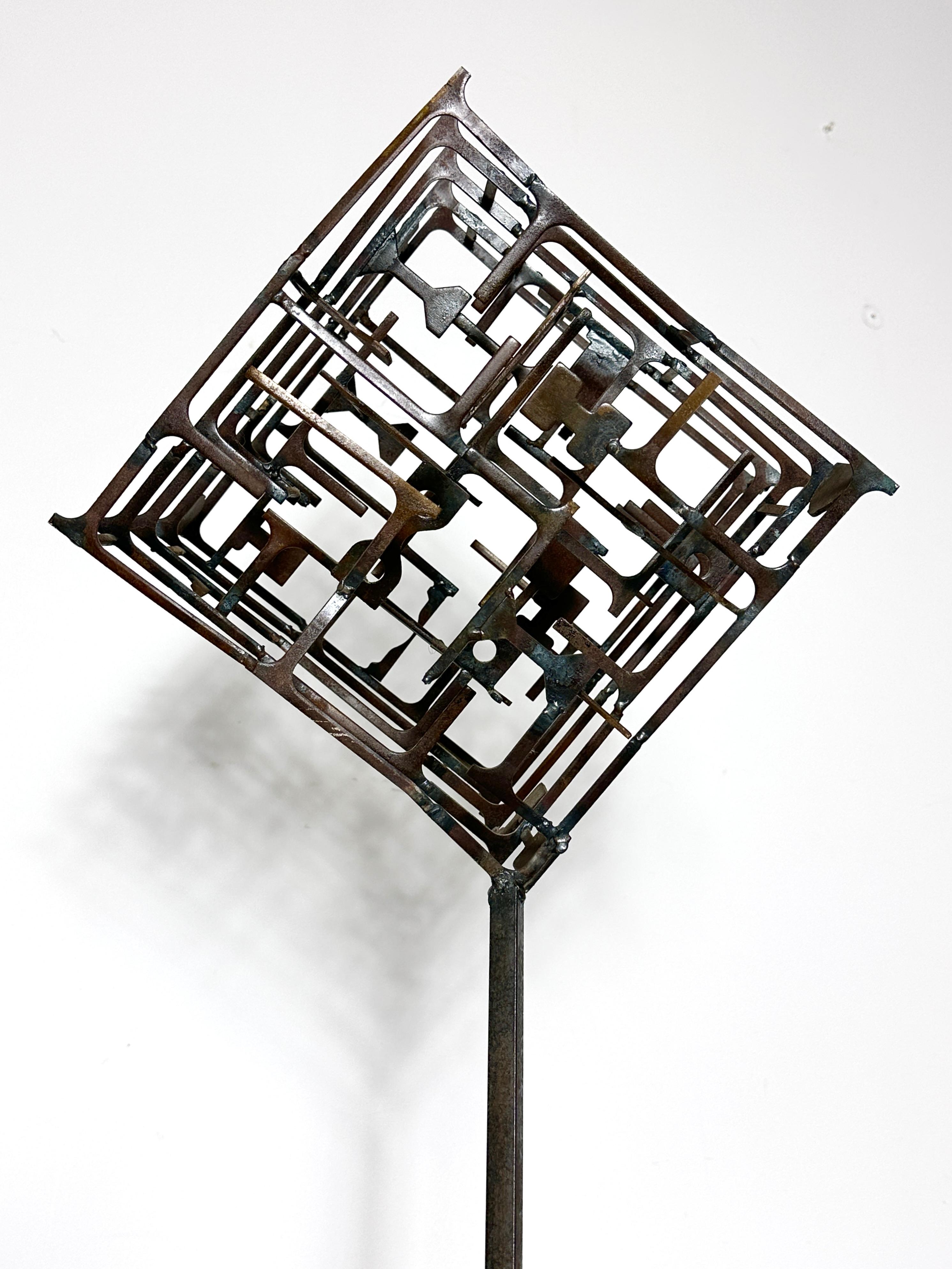 Sculpture abstraite de l'artiste Fred Scott, du nord de l'Ohio, vers les années 1960
Cube labyrinthe en acier soudé monté sur une base en bois et acrylique.
Acquise auprès de la succession de l'artiste, avec les étiquettes d'exposition originales à
