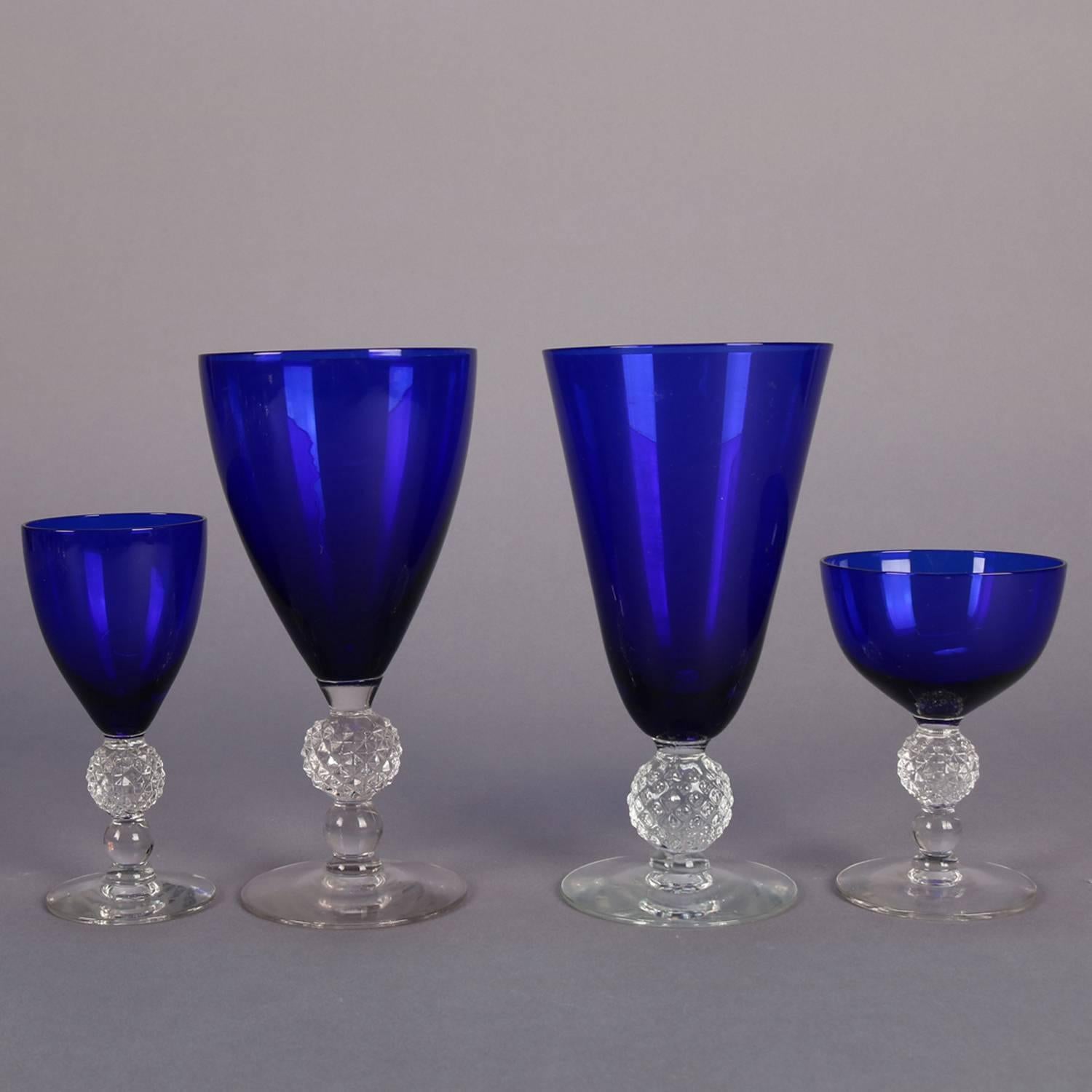 38 Piece set of Ritz Blue stemware in golf ball pattern by Morgantown Glass Company features cobalt blue glass bowls with clear crystal bases having spherical stem with diamond divots, 20th century

Measure - Water goblets 6.75
