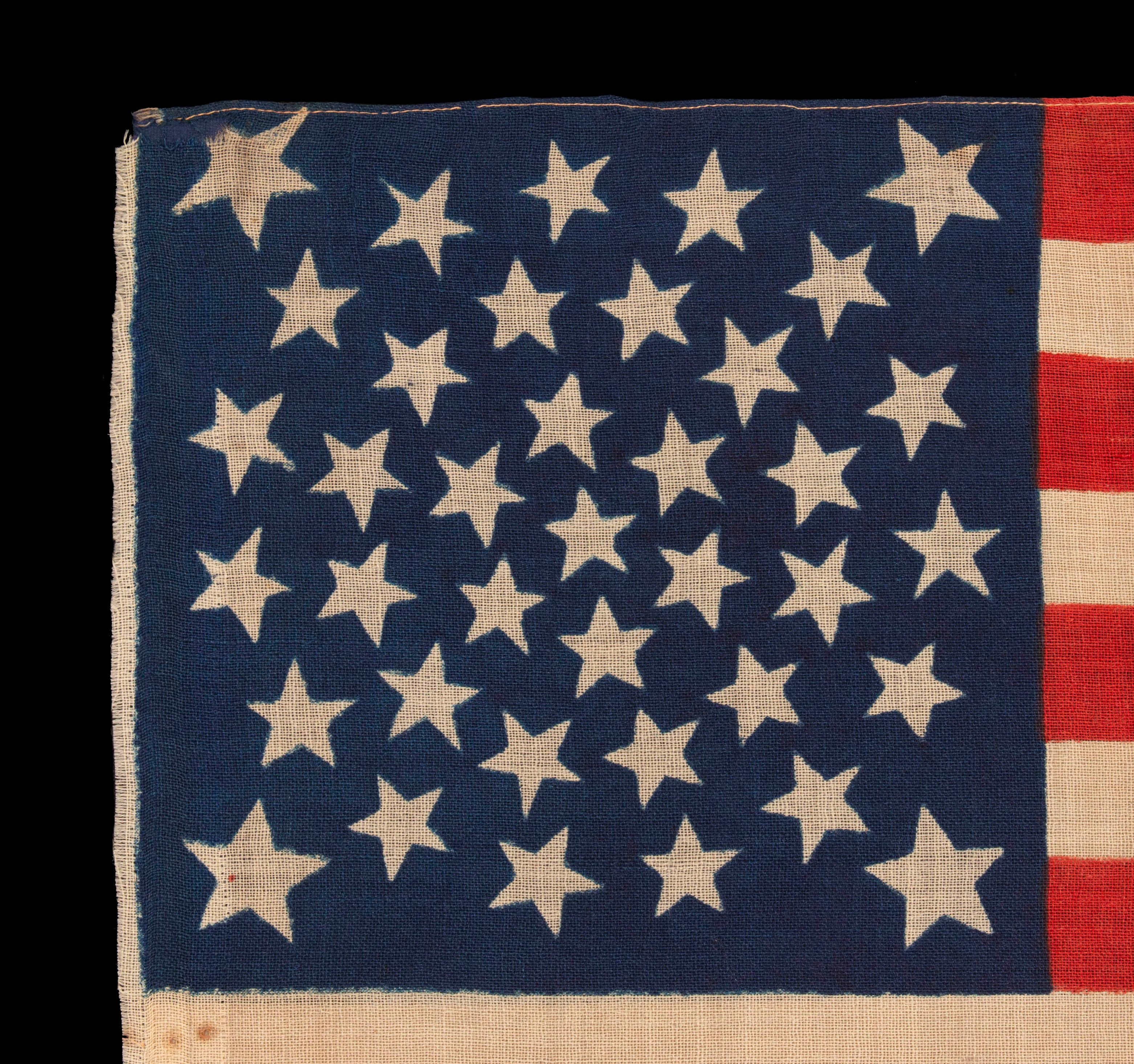 38 ESTRELLAS, ESTADIDAD DE COLORADO, UNA ESCASA Y HERMOSA BANDERA AMERICANA ANTIGUA CON UN DISEÑO DE MEDALLÓN Y 4 GRANDES ESTRELLAS EN LAS ESQUINAS, TEÑIDA A PRESIÓN SOBRE BANDERÍN DE LANA, HECHA POR LOS HERMANOS HORSTMANN EN FILADELFIA PARA EL