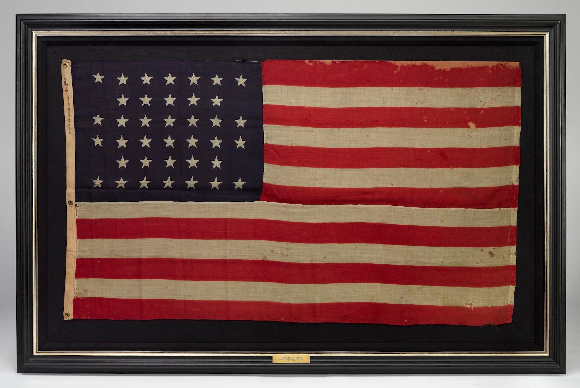 This is an original 38-star American flag. The flag dates to 1876, when Colorado joined the Union as the 38th state. The flag has a wool bunting canton with 38 clamp-dyed stars, configured in an unusual notched pattern. The star pattern features