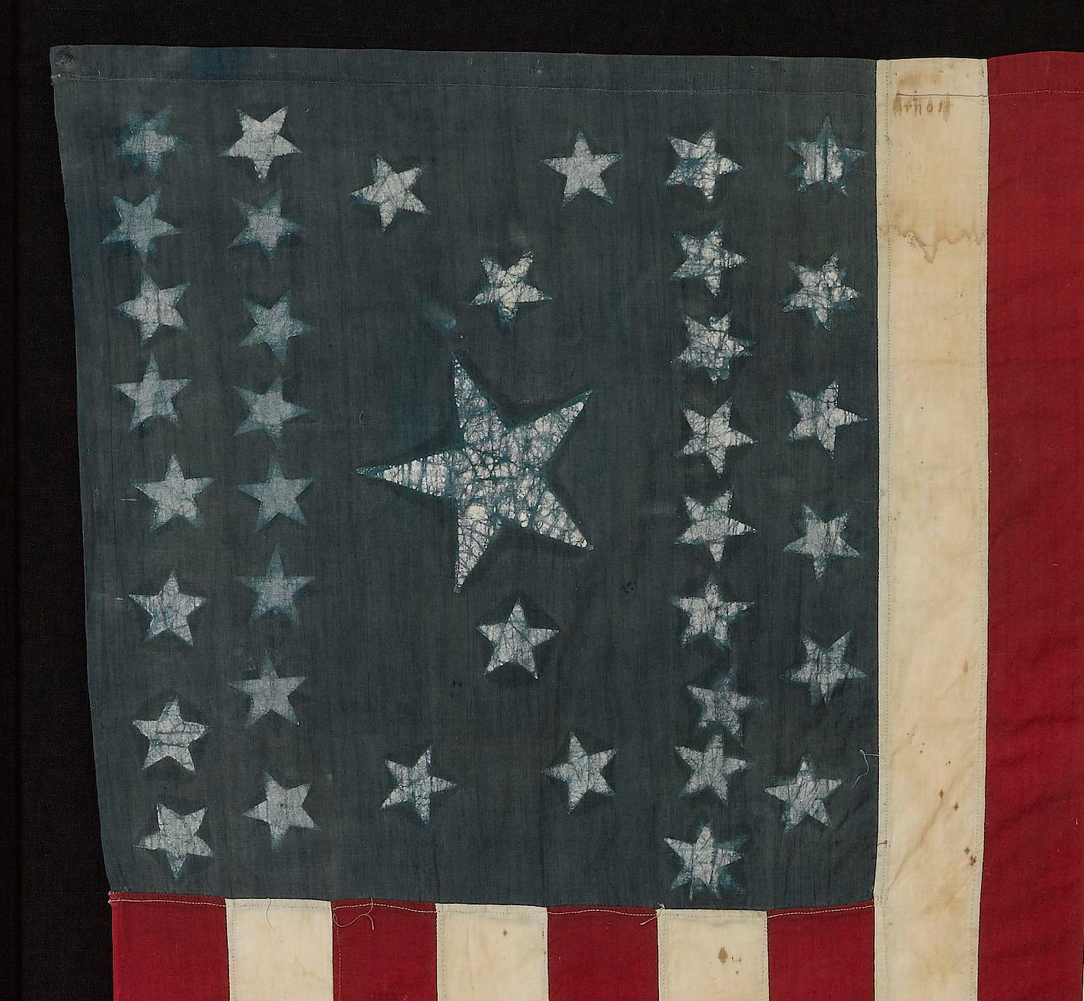 This is an original 38-star American flag. The flag dates to 1876, when Colorado joined the Union as the 38th state. The flag is made of cotton, with a blue canton featuring thirty-eight stenciled white stars. The stars are arranged in an unusual