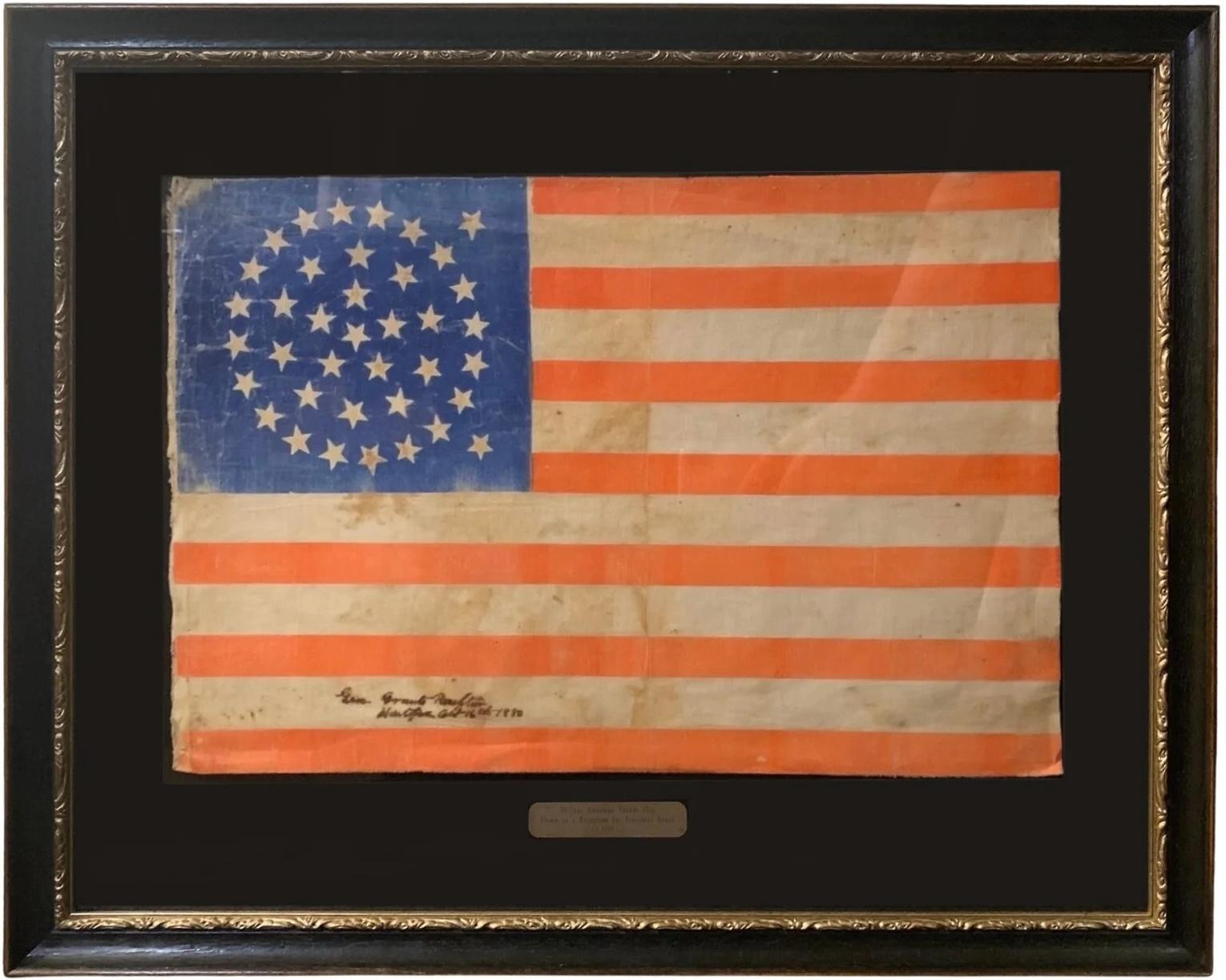 This is a beautifully colored 38-star American parade flag, flown at a public reception for Ulysses S. Grant in October of 1880. This printed flag features a rare, triple medallion star pattern, with three rings of stars, a central star, and two