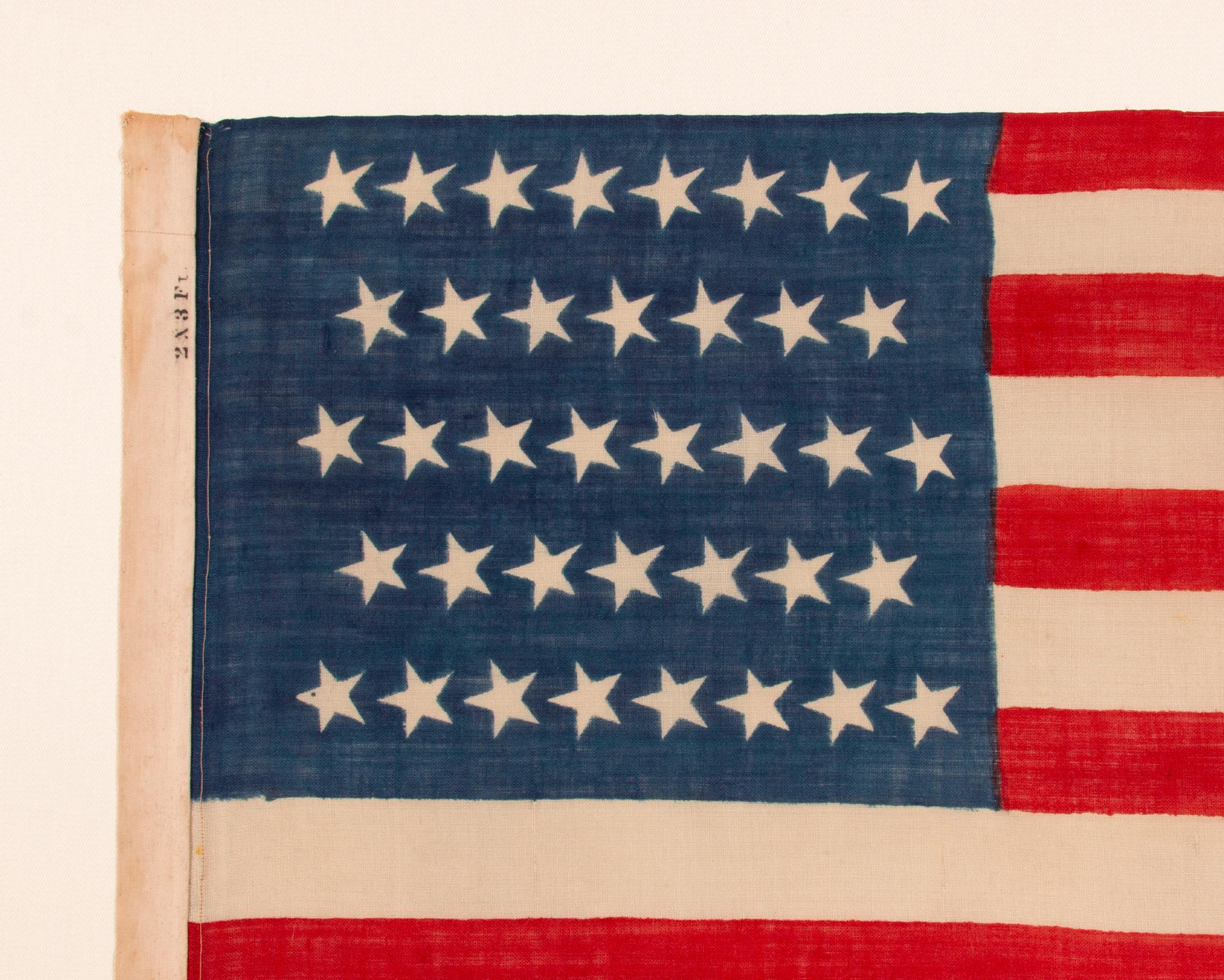 38 CANTED STARS IN STAGGERED ROWS, ON A CLAMP-DYED, WOOL, ANTIQUE AMERICAN FLAG MADE BY THE HORSTMANN BROTHERS IN PHILADELPHIA, ALMOST CERTAINLY FOR DISPLAY AT THE 1876 CENTENNIAL EXPOSITION; A VERY RARE EXAMPLE WITH STRONG COLORS AND GREAT TEXTURE;