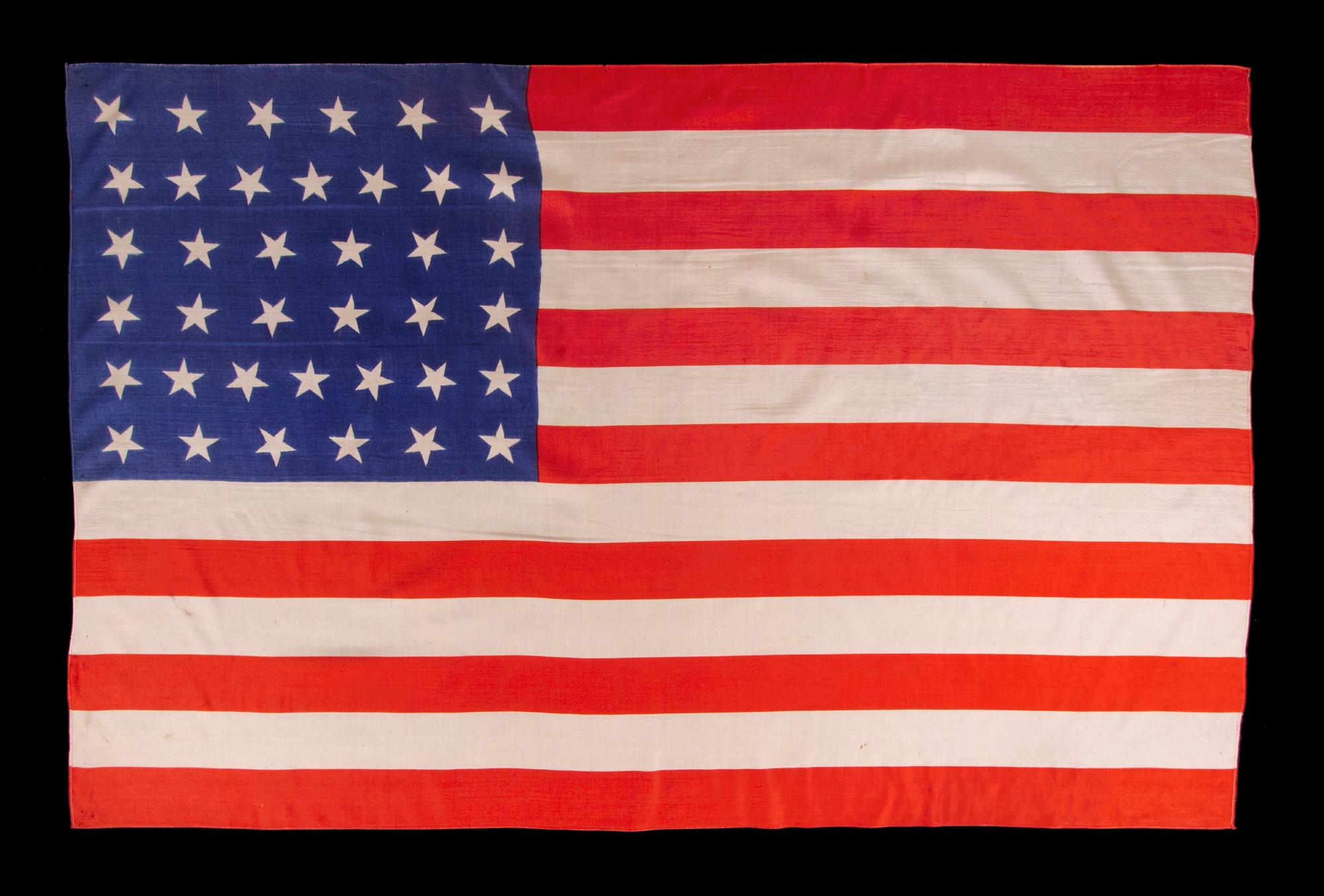 38 star antique American parade flag with scattered star orientation, made of silk, with generous scale and vivid colors, Colorado Statehood, 1876-1889

38 star American national parade flag, printed on silk. The stars are arranged in justified,