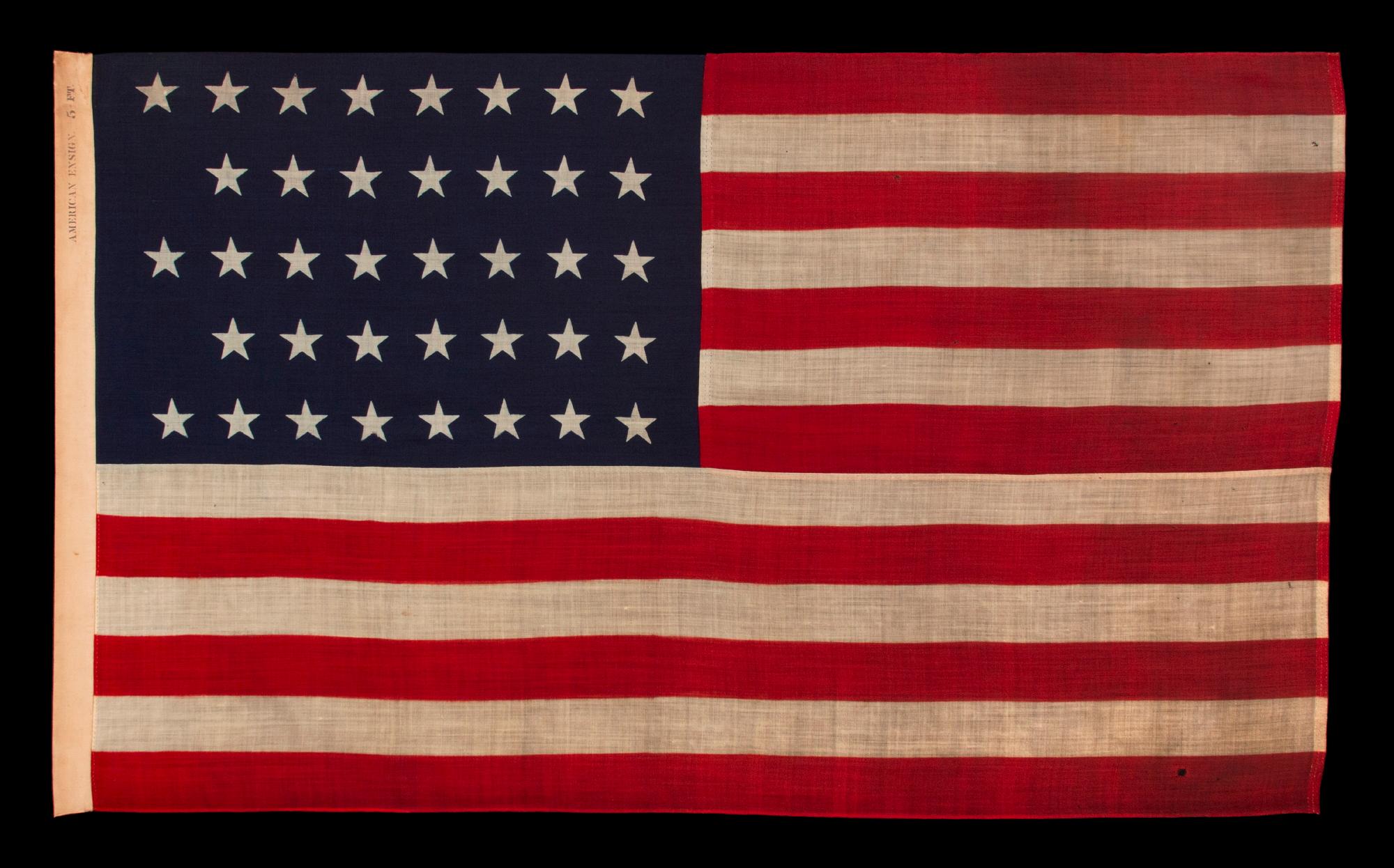 38 STAR ANTIQUE AMERICAN FLAG WITH A NOTCHED CONFIGURATION, MADE BY THE U.S. BUNTING COMPANY IN LOWELL, MASSACHUSETTS, REFLECTS THE ERA OF COLORADO STATEHOOD, circa 1876-1889

38 star American national flag, press-dyed on wool bunting. The stars are