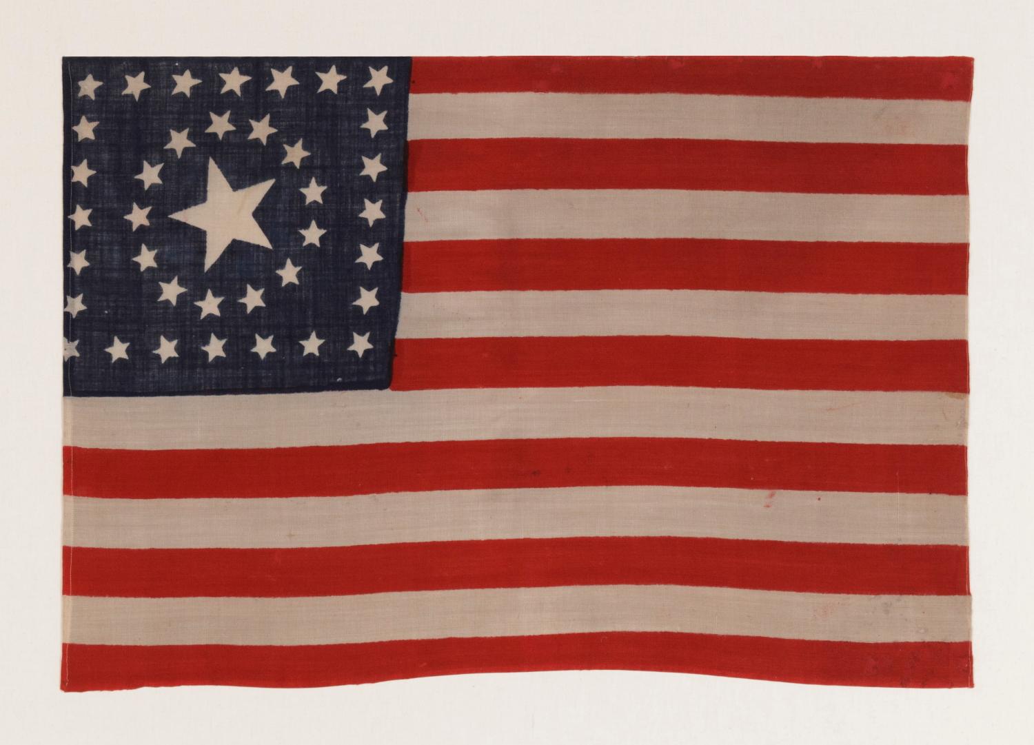 38 STARS IN A RARE CIRCLE-IN-A-SQUARE MEDALLION WITH A HUGE CENTER STAR, MADE FOR THE 1876 CENTENNIAL INTERNATIONAL EXPOSITION BY HORSTMANN BROS. IN PHILADELPHIA 

38 star American national parade flag, press-dyed on wool bunting, with an especially