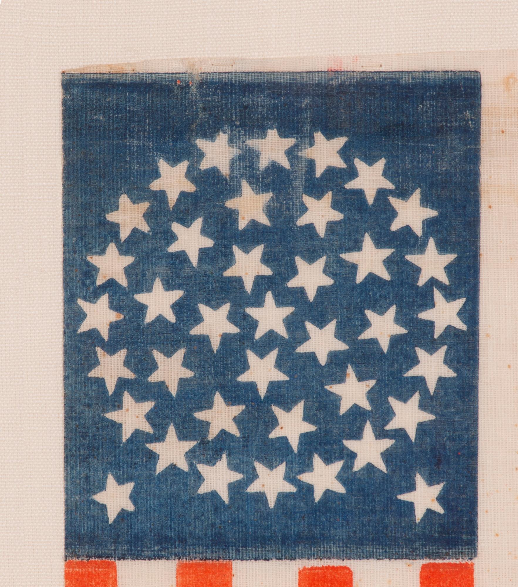 38 STARS IN A MEDALLION CONFIGURATION WITH 2 OUTLIERS, ON AN ANTIQUE AMERICAN FLAG WITH VIBRANT COLORATION, REFLECTS COLORADO STATEHOOD, 1876-1889, ILLUSTRATED IN “THE STARS & STRIPES: FABRIC OF THE AMERICAN SPIRIT” by RICHARD PIERCE, 2005

38 star
