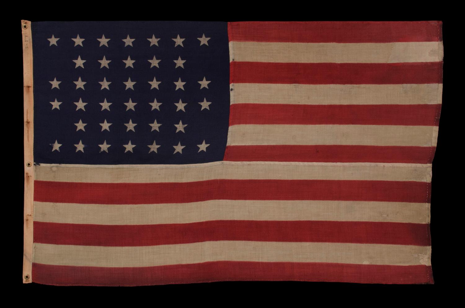 38 Sterne in einem gekerbten:: kreuzschraffierten Muster auf einer antiken amerikanischen Flagge:: hergestellt von der U.S. Bunting Company in Lowell:: Massachusetts:: 1876-1889:: Colorado Statehood: 


amerikanische Nationalflagge mit 38 Sternen::
