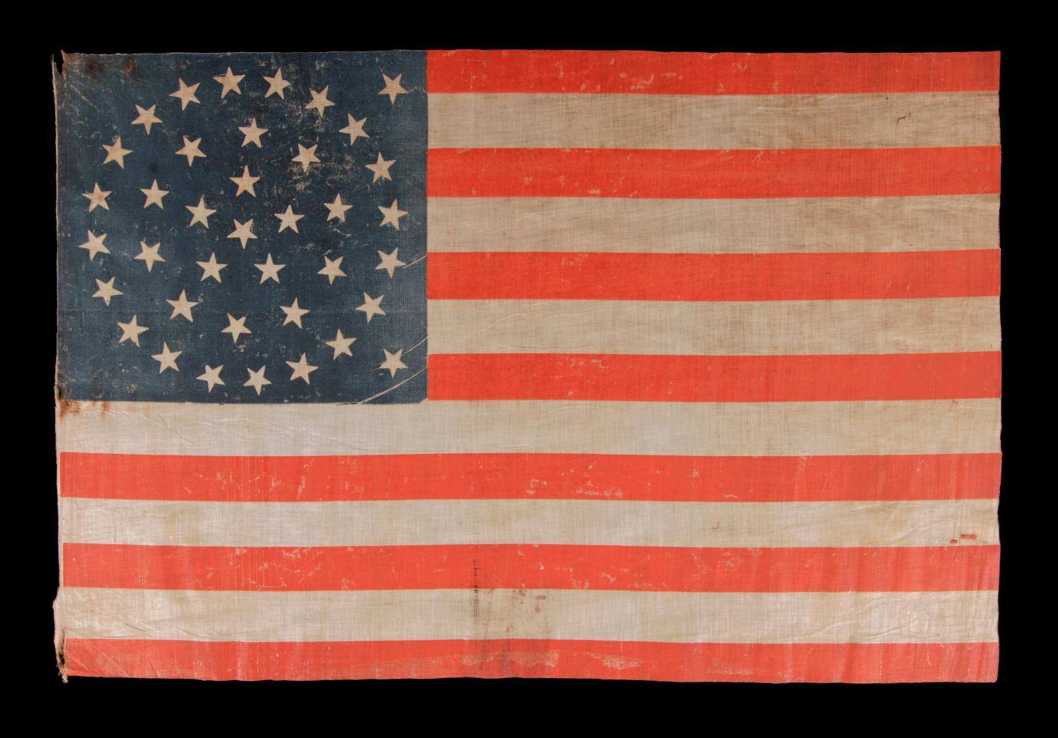 38 STARS IN A MEDALLION CONFIGURATION, WITH 2 OUTLIERS, ON A LARGE SCALE ANTIQUE AMERICAN PARADE FLAG, 1876-1889, COLORADO STATEHOOD:

 38 star American parade flag, block-printed by hand on coarse, glazed cotton. The stars are arranged in a